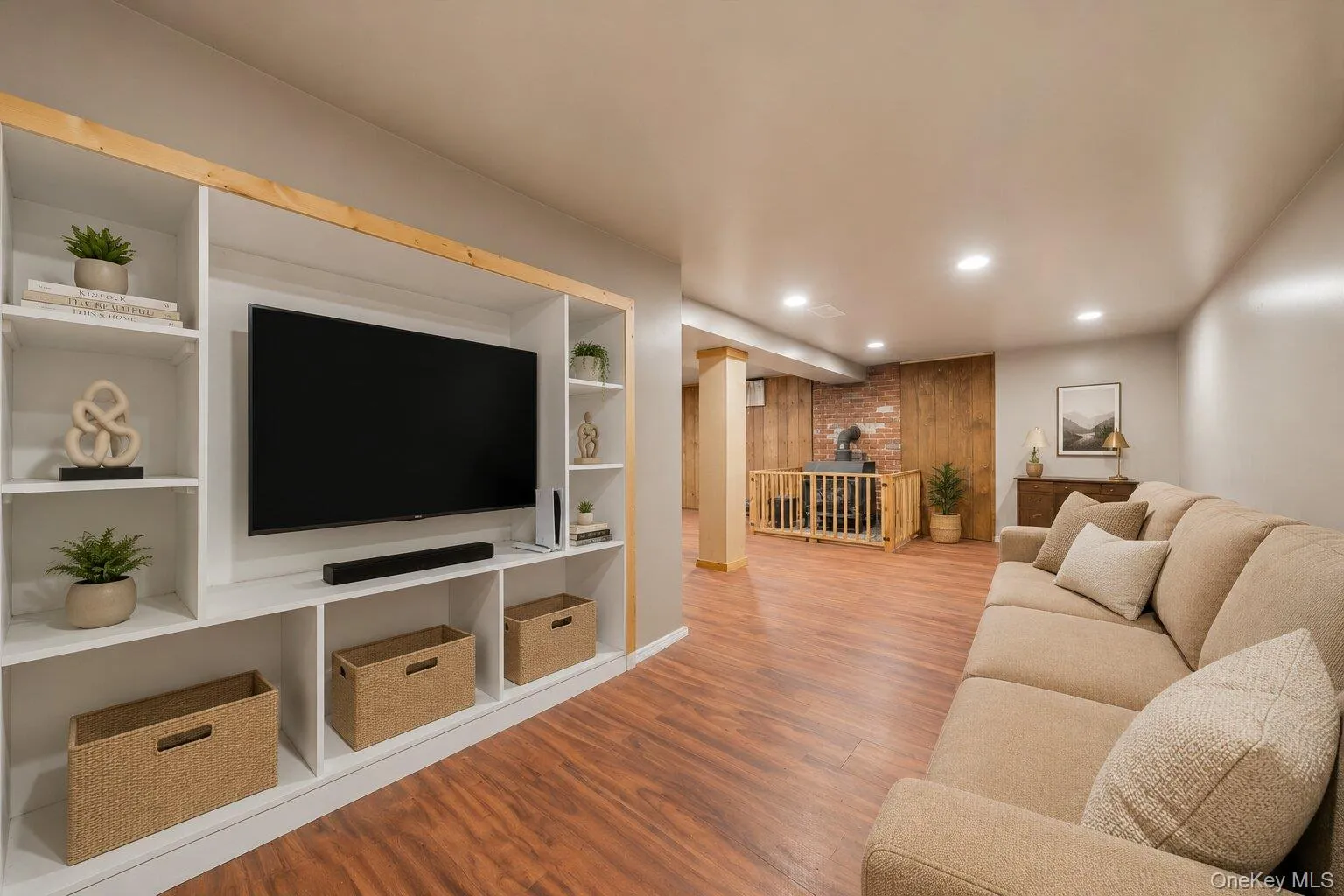 Virtually Staged: Finished lower-level space featuring wood-look flooring, recessed lighting, a brick chimney with a supplemental stove, and room for exercise equipment or hobbies. Virtually Staged: Finished lower-level space featuring wood-look flooring, recessed lighting, a brick chimney with a supplemental stove, and room for exercise equipment or hobbies.
