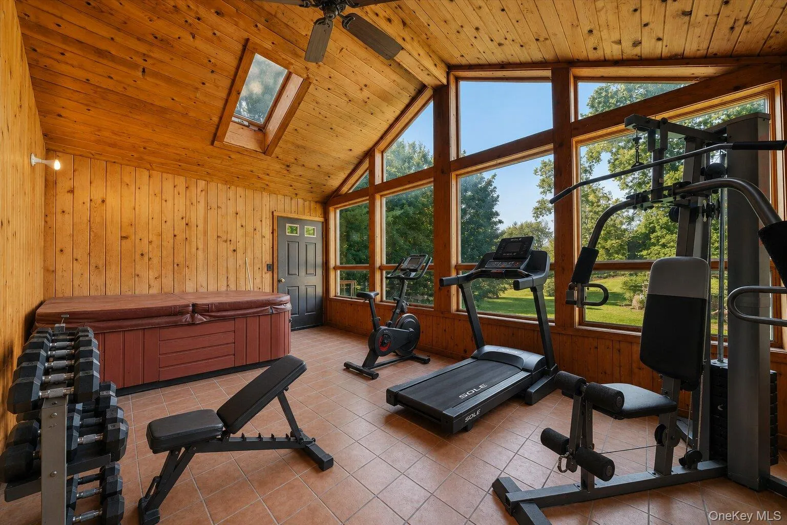 Virtually Staged: Spacious enclosed sunroom featuring a vaulted wood ceiling, skylights, expansive windows, a hot tub, and plenty of room for exercise equipment. Virtually Staged: Spacious enclosed sunroom featuring a vaulted wood ceiling, skylights, expansive windows, a hot tub, and plenty of room for exercise equipment.