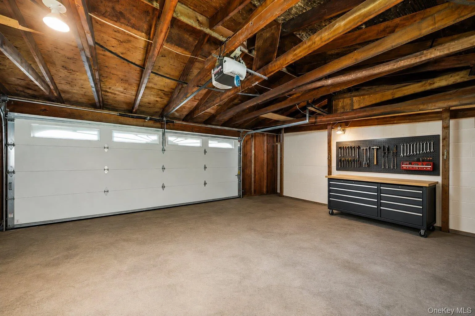 Attached garage offering parking, storage, a garage-door opener, and space for a workbench or tool organization. Attached garage offering parking, storage, a garage-door opener, and space for a workbench or tool organization.