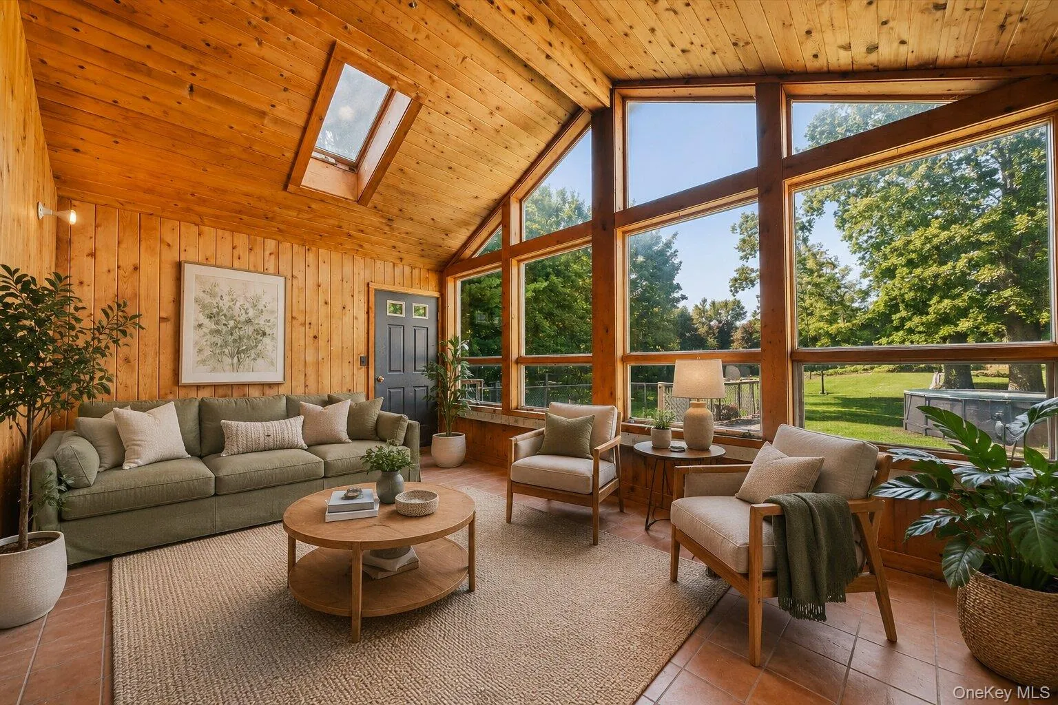 Virtually Staged Sunroom: Can also be a - Sun-filled enclosed porch virtually staged as an inviting living area, highlighting the soaring wood ceiling, skylights, and beautiful backyard views. Virtually Staged Sunroom: Can also be a - Sun-filled enclosed porch virtually staged as an inviting living area, highlighting the soaring wood ceiling, skylights, and beautiful backyard views.