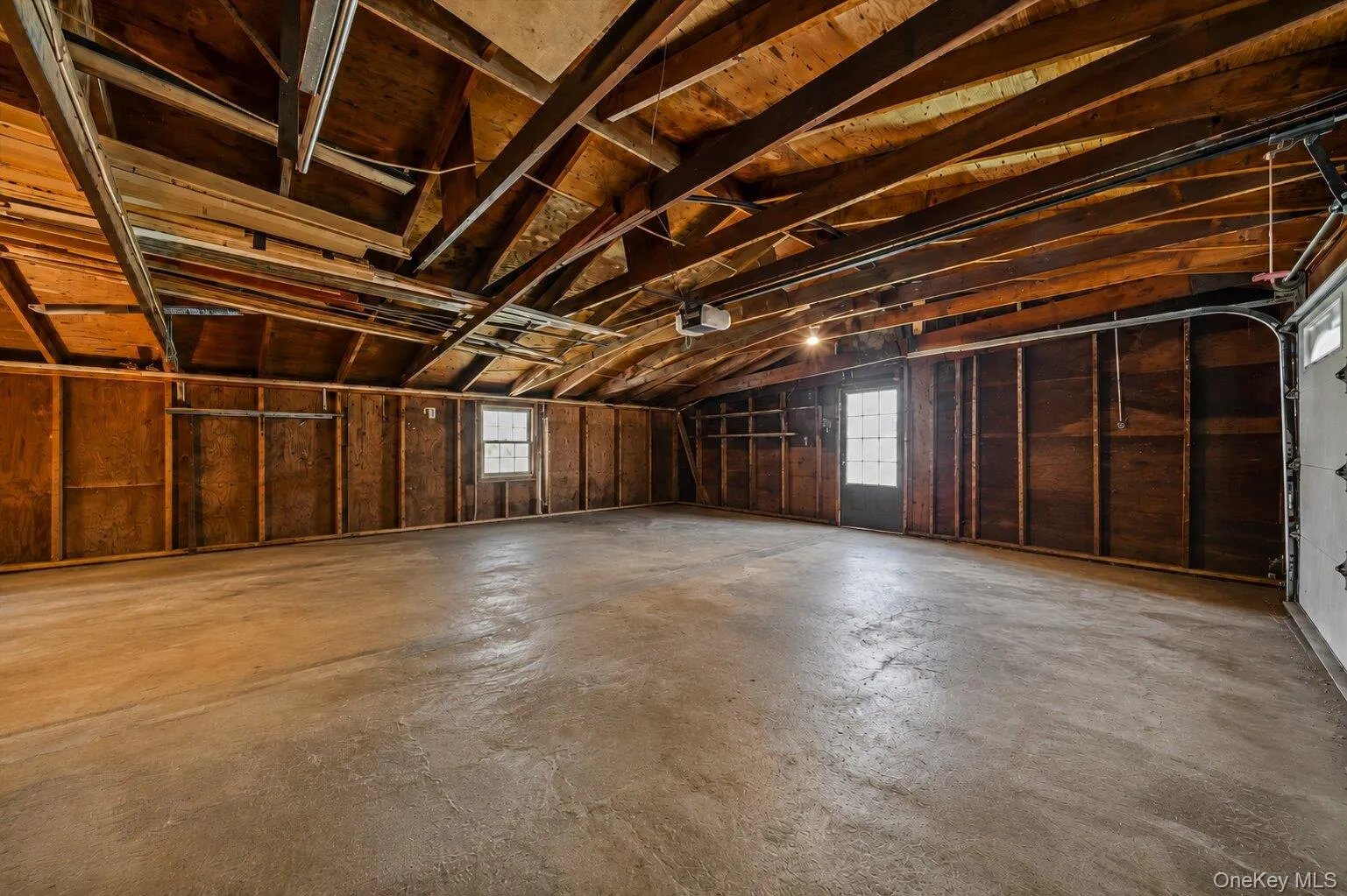 Attached garage offering parking, storage, a garage-door opener, and space for a workbench or tool organization. Attached garage offering parking, storage, a garage-door opener, and space for a workbench or tool organization.