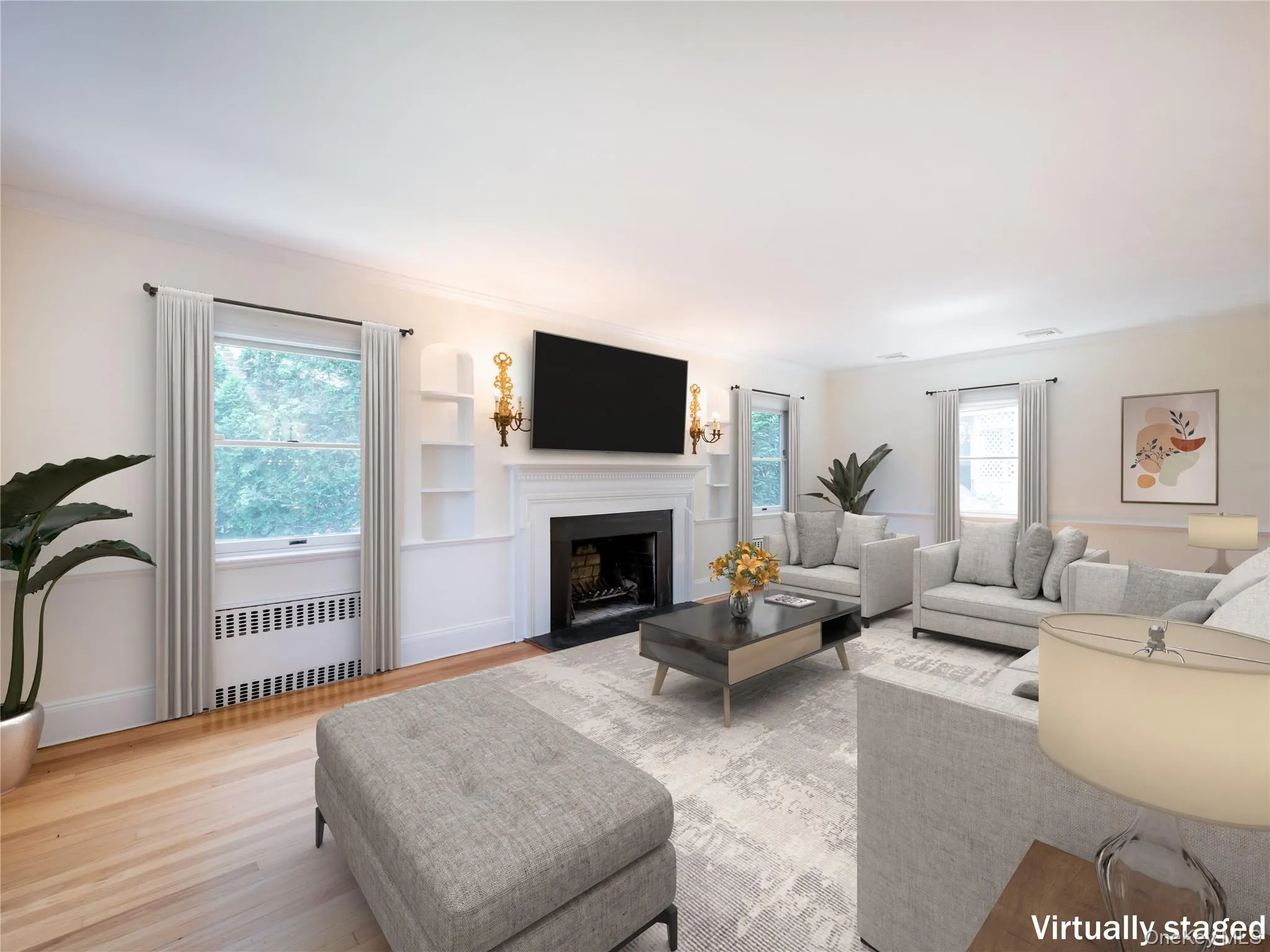 Living room with radiator, a fireplace with flush hearth, wood finished floors, and ornamental molding Living room with radiator, a fireplace with flush hearth, wood finished floors, and ornamental molding