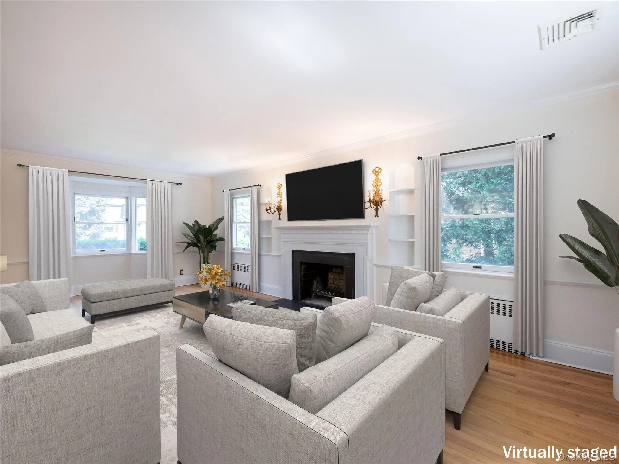 Living area featuring radiator, a fireplace, light wood finished floors, and ornamental molding Living area featuring radiator, a fireplace, light wood finished floors, and ornamental molding