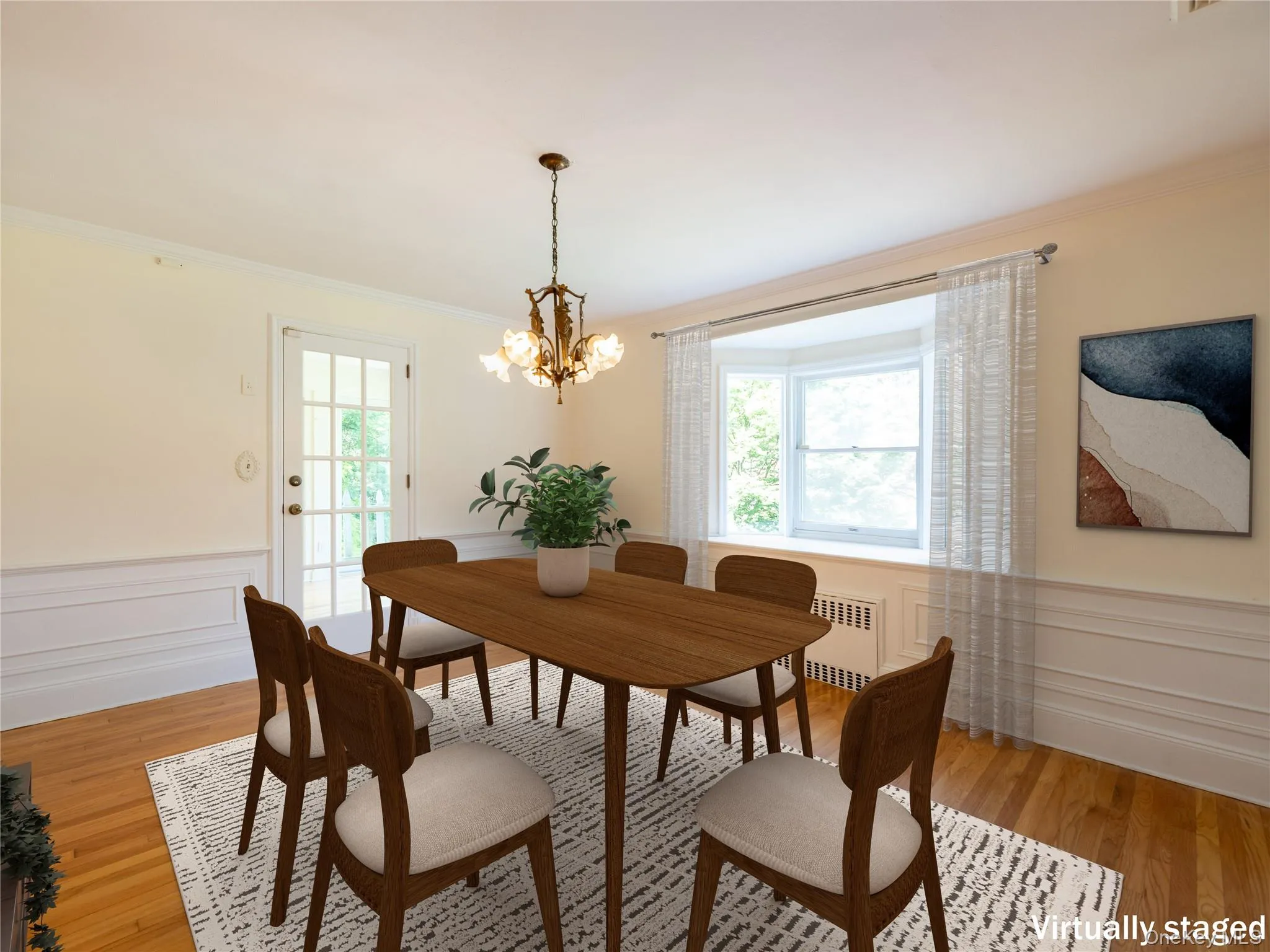Dining area featuring radiator heating unit, crown molding, plenty of natural light, a chandelier, and a wainscoted wall Dining area featuring radiator heating unit, crown molding, plenty of natural light, a chandelier, and a wainscoted wall