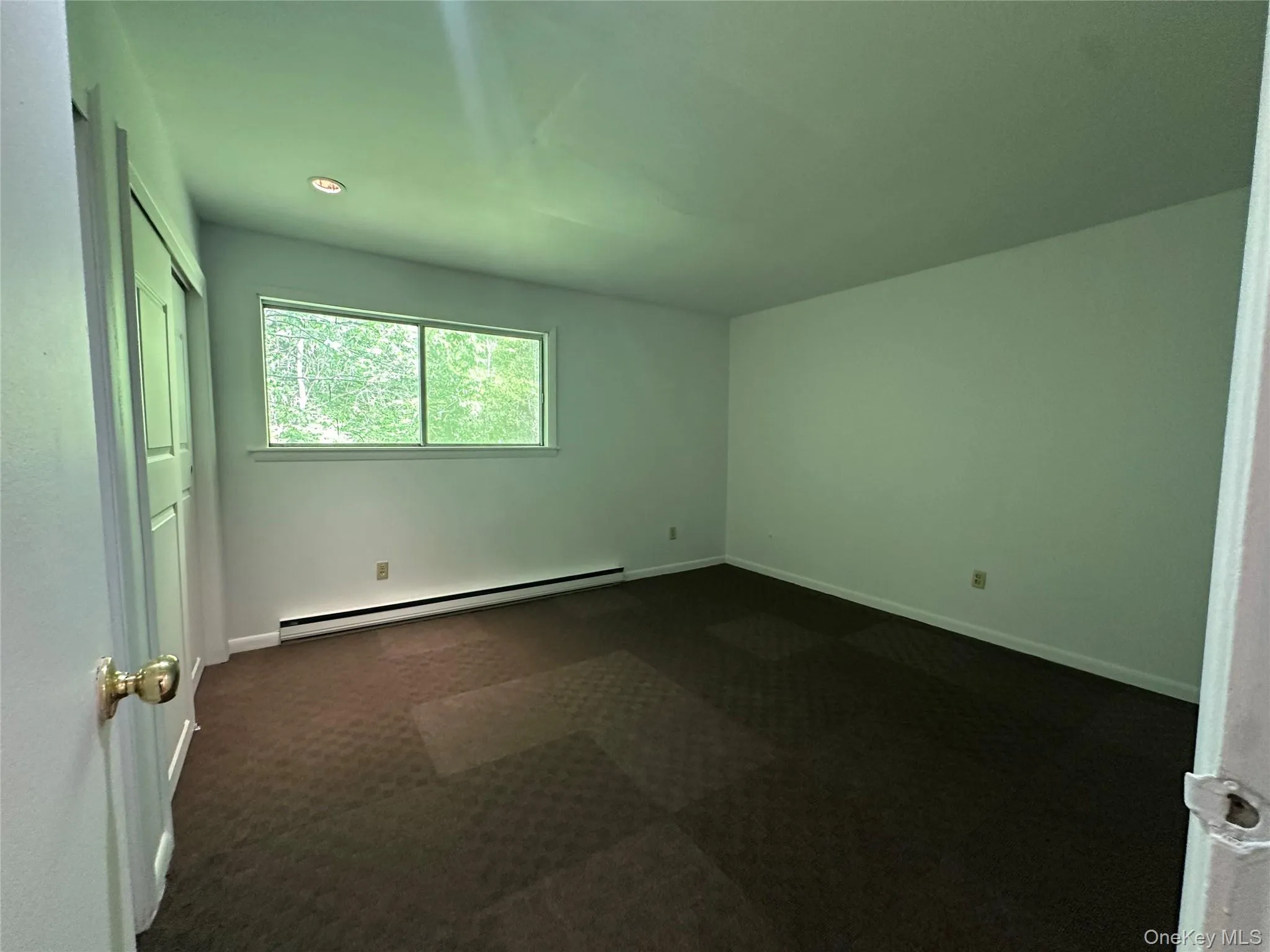 Unfurnished bedroom featuring a baseboard heating unit, dark carpet, baseboards, and recessed lighting Unfurnished bedroom featuring a baseboard heating unit, dark carpet, baseboards, and recessed lighting