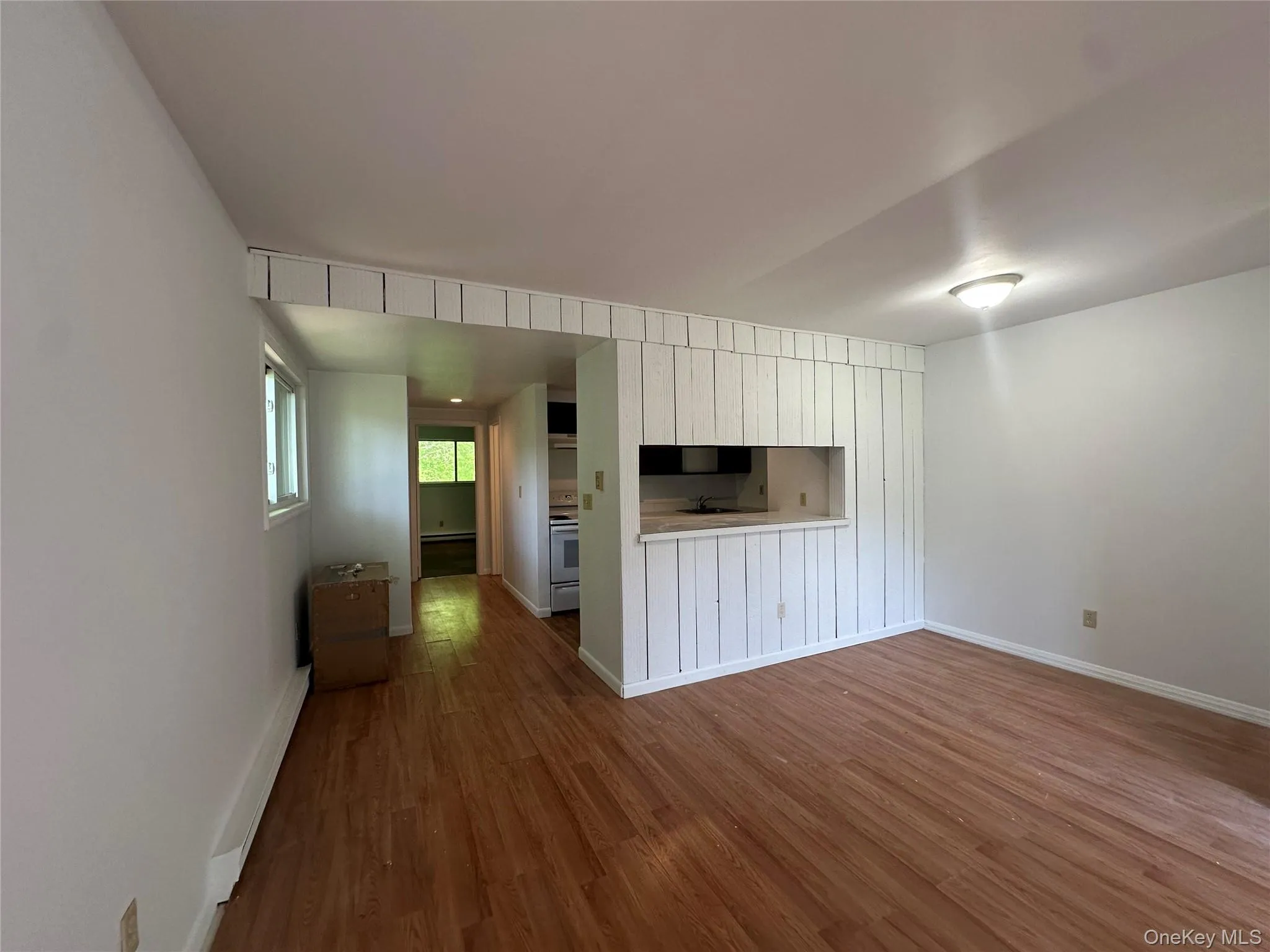 Unfurnished living room featuring dark wood finished floors and baseboards Unfurnished living room featuring dark wood finished floors and baseboards