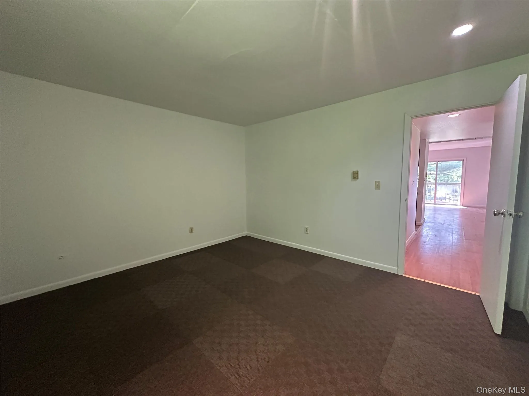 Spare room with dark colored carpet, baseboards, and recessed lighting Spare room with dark colored carpet, baseboards, and recessed lighting