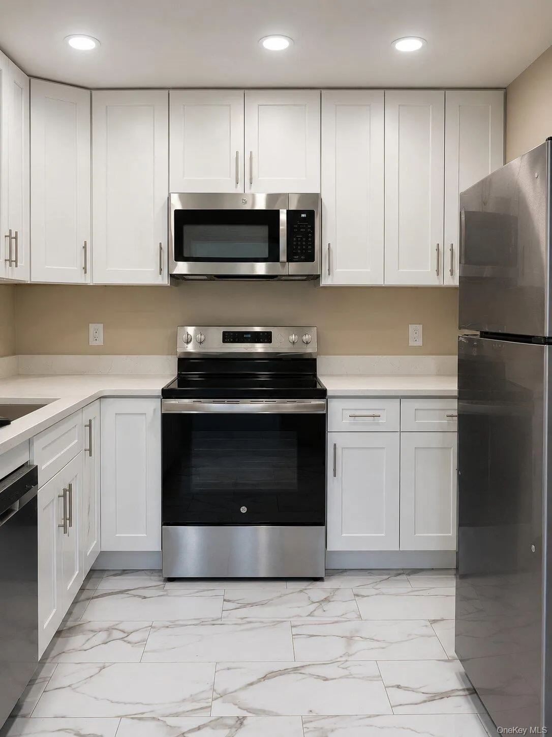 Updated Kitchen – Beautifully renovated kitchen featuring white cabinetry, quartz-style countertops, stainless-steel appliances, recessed lighting, and elegant tile flooring. Updated Kitchen – Beautifully renovated kitchen featuring white cabinetry, quartz-style countertops, stainless-steel appliances, recessed lighting, and elegant tile flooring.
