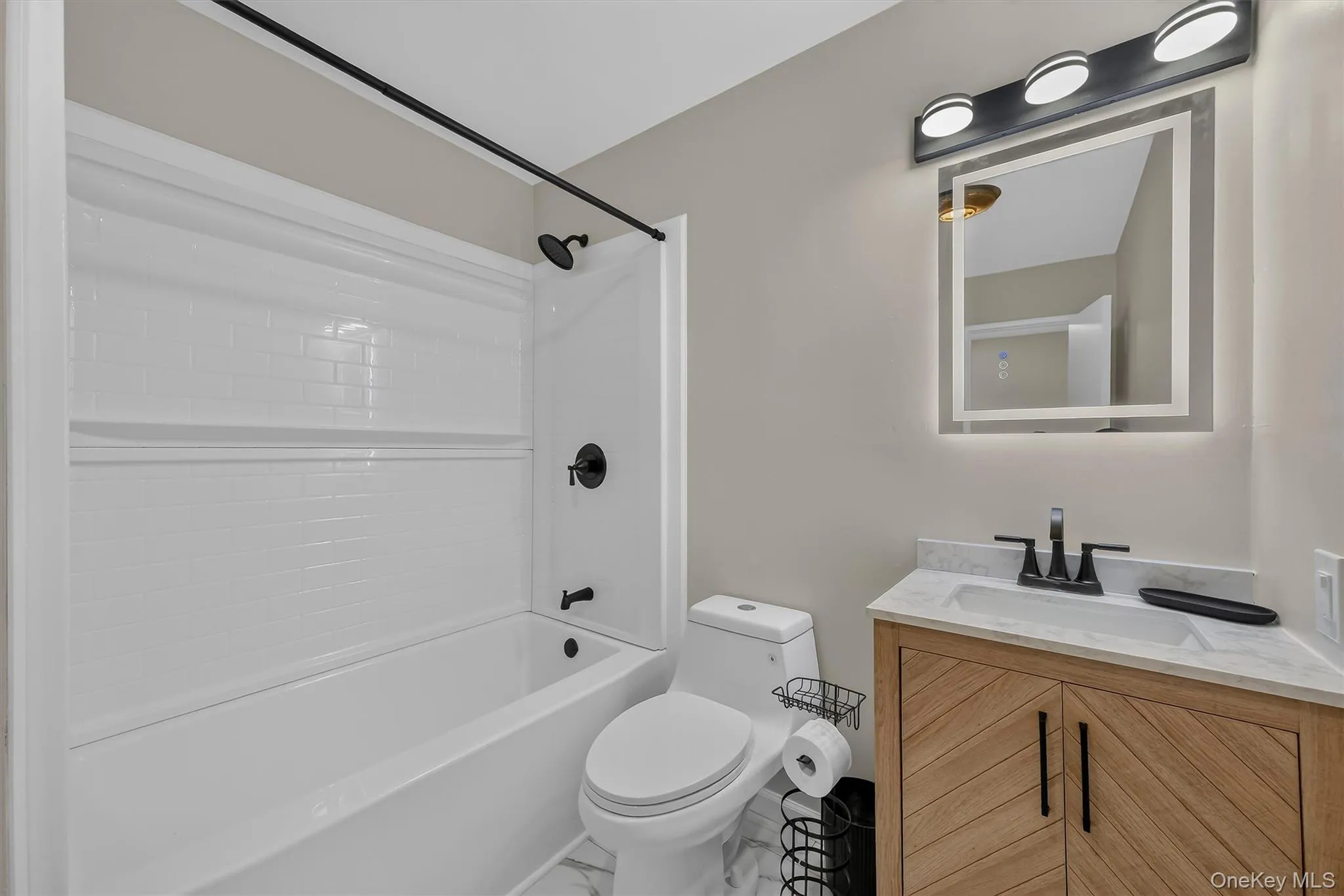 Bathroom Detail View – A closer look at the stylish vanity, contemporary lighting, updated fixtures, and clean white tub surround with convenient built-in shelving. Bathroom Detail View – A closer look at the stylish vanity, contemporary lighting, updated fixtures, and clean white tub surround with convenient built-in shelving.