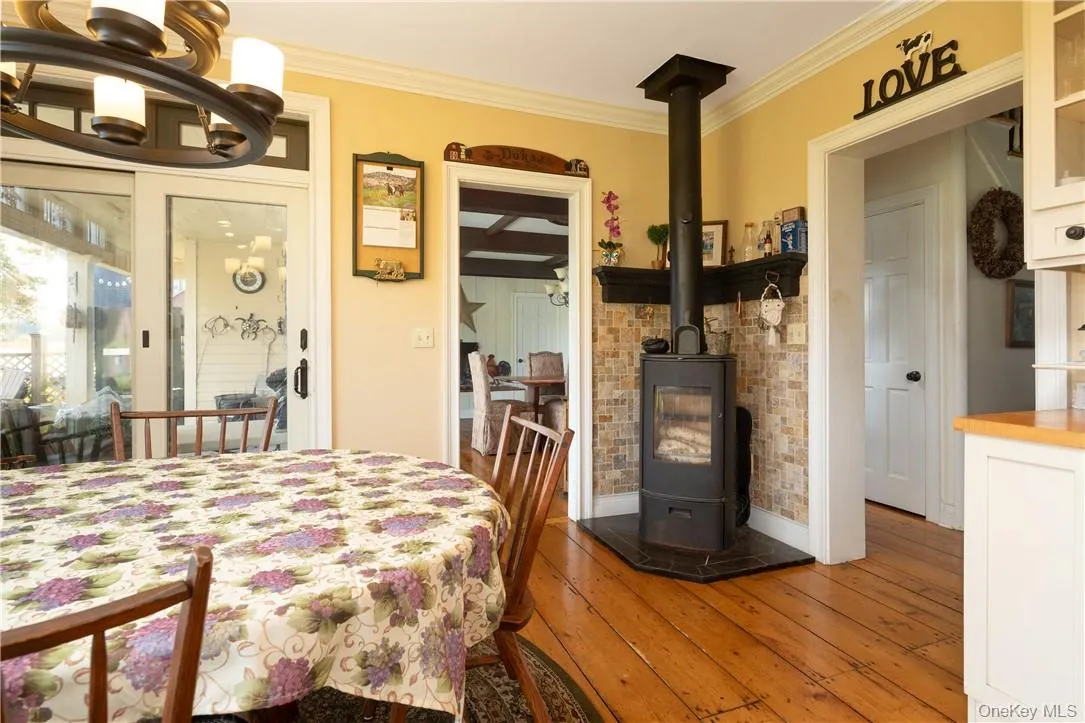 Dining area featuring ornamental molding, hardwood / wood-style floors, ,and a wood stove Dining area featuring ornamental molding, hardwood / wood-style floors, ,and a wood stove