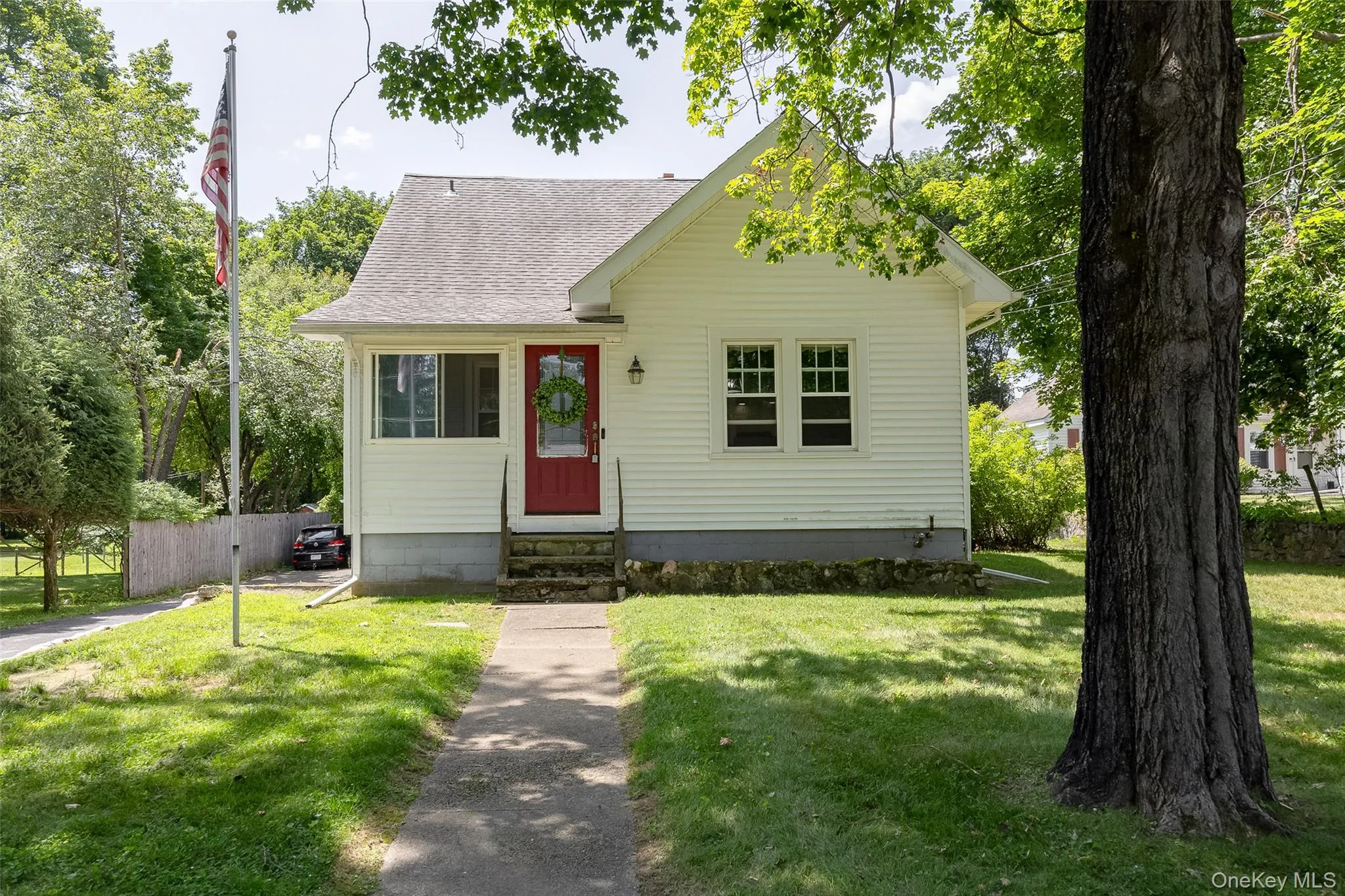Charming single-story residence featuring white siding and a prominent red entry door Charming single-story residence featuring white siding and a prominent red entry door