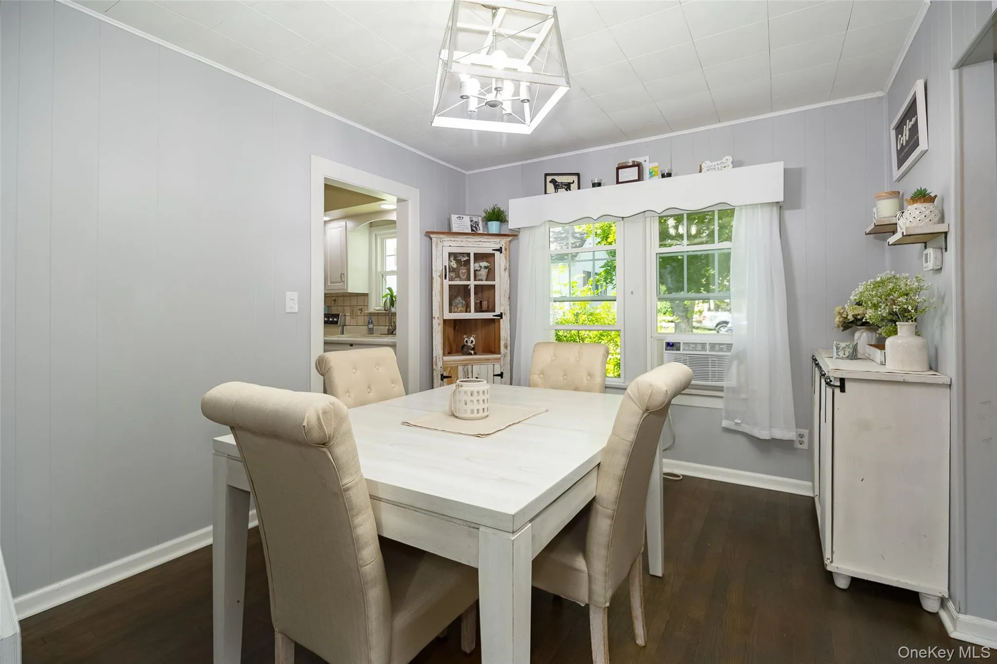 Dining area featuring dark wood-finish flooring, light grey walls, and a white beadboard ceiling Dining area featuring dark wood-finish flooring, light grey walls, and a white beadboard ceiling
