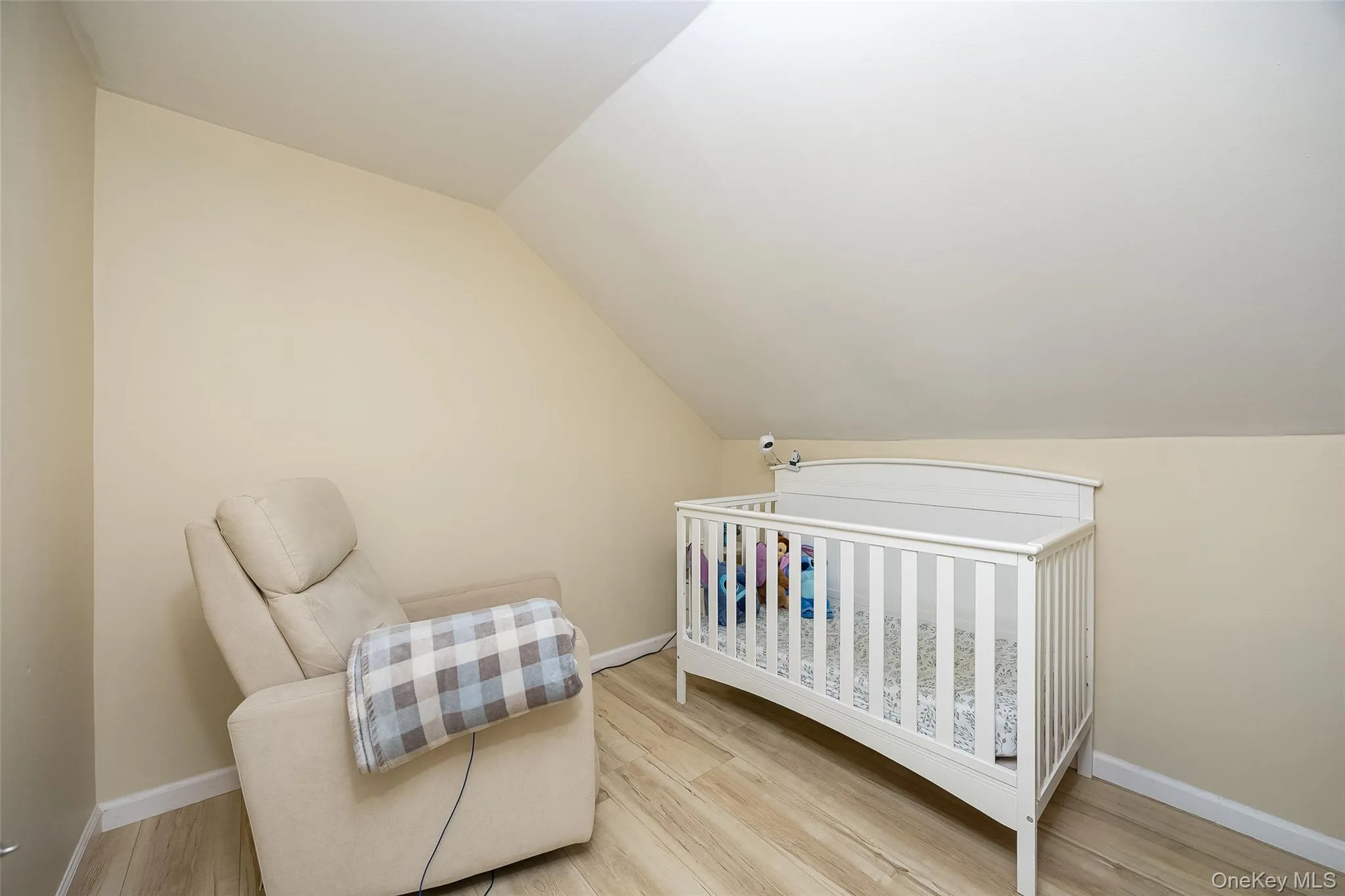 Room featuring angled ceilings and neutral-toned walls Room featuring angled ceilings and neutral-toned walls