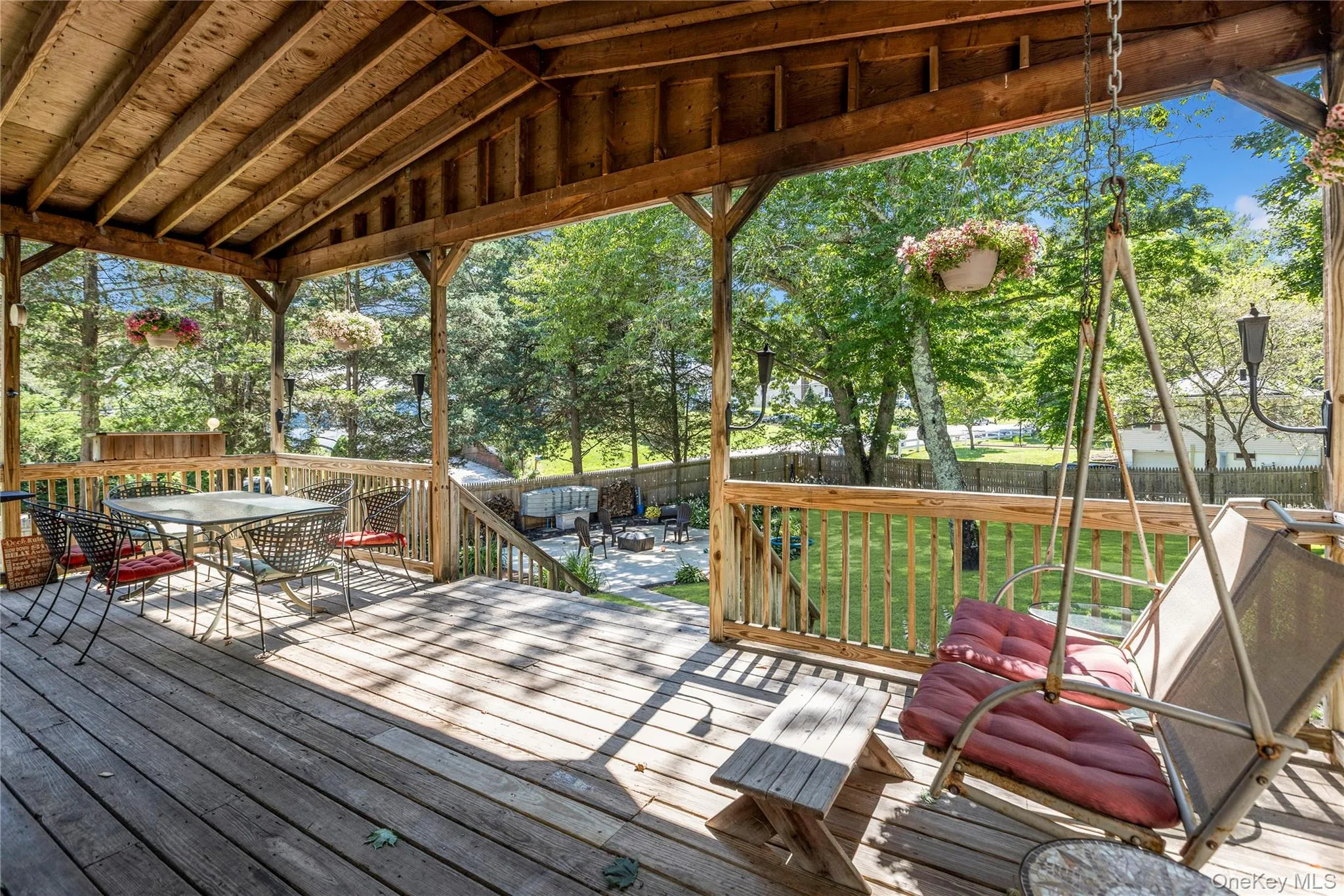Expansive outdoor deck featuring wood flooring, a covered wooden ceiling, and sturdy wood railings Expansive outdoor deck featuring wood flooring, a covered wooden ceiling, and sturdy wood railings