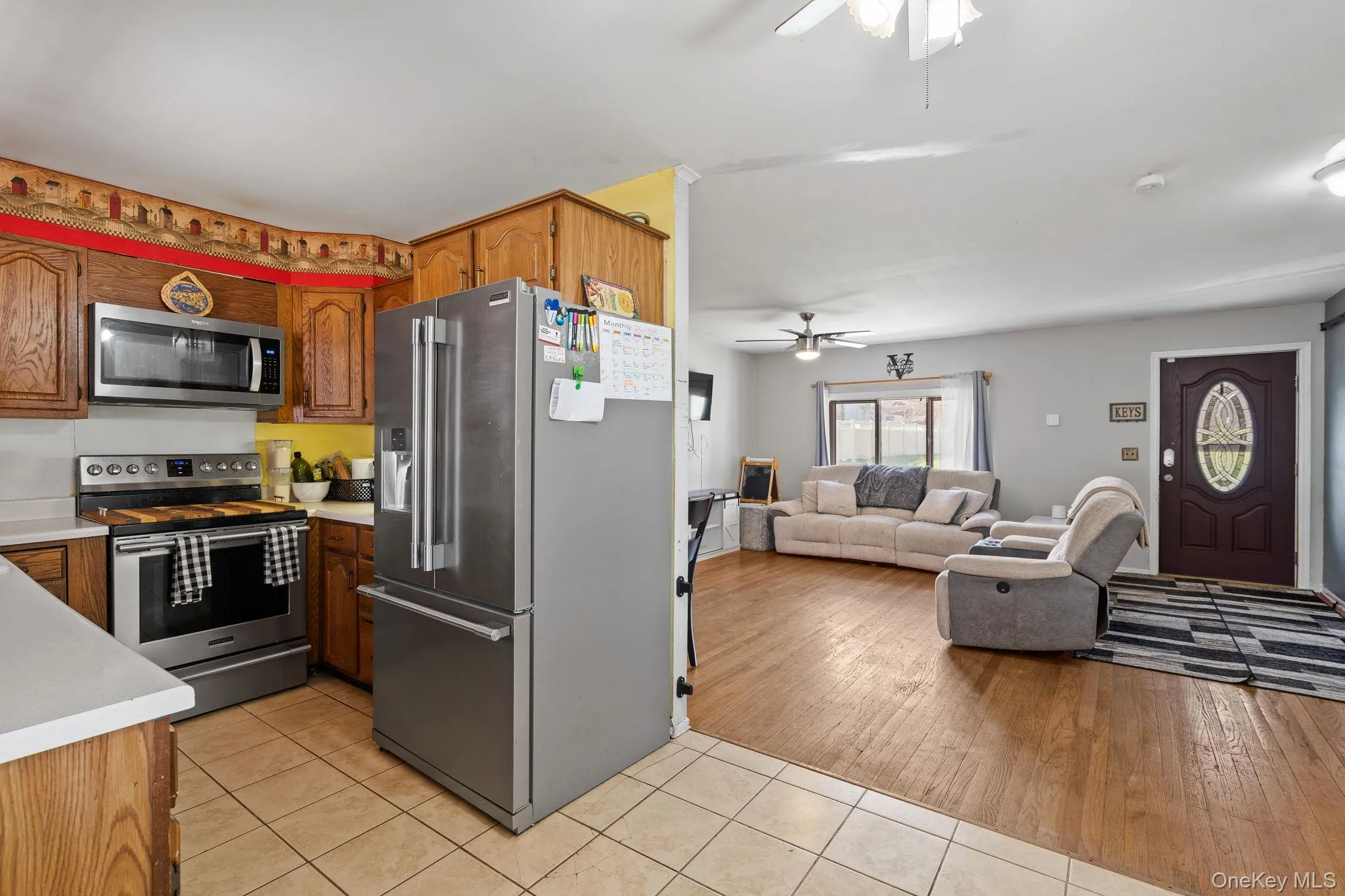 Kitchen featuring light countertops, ceiling fan, appliances with stainless steel finishes, and light tile patterned floors Kitchen featuring light countertops, ceiling fan, appliances with stainless steel finishes, and light tile patterned floors
