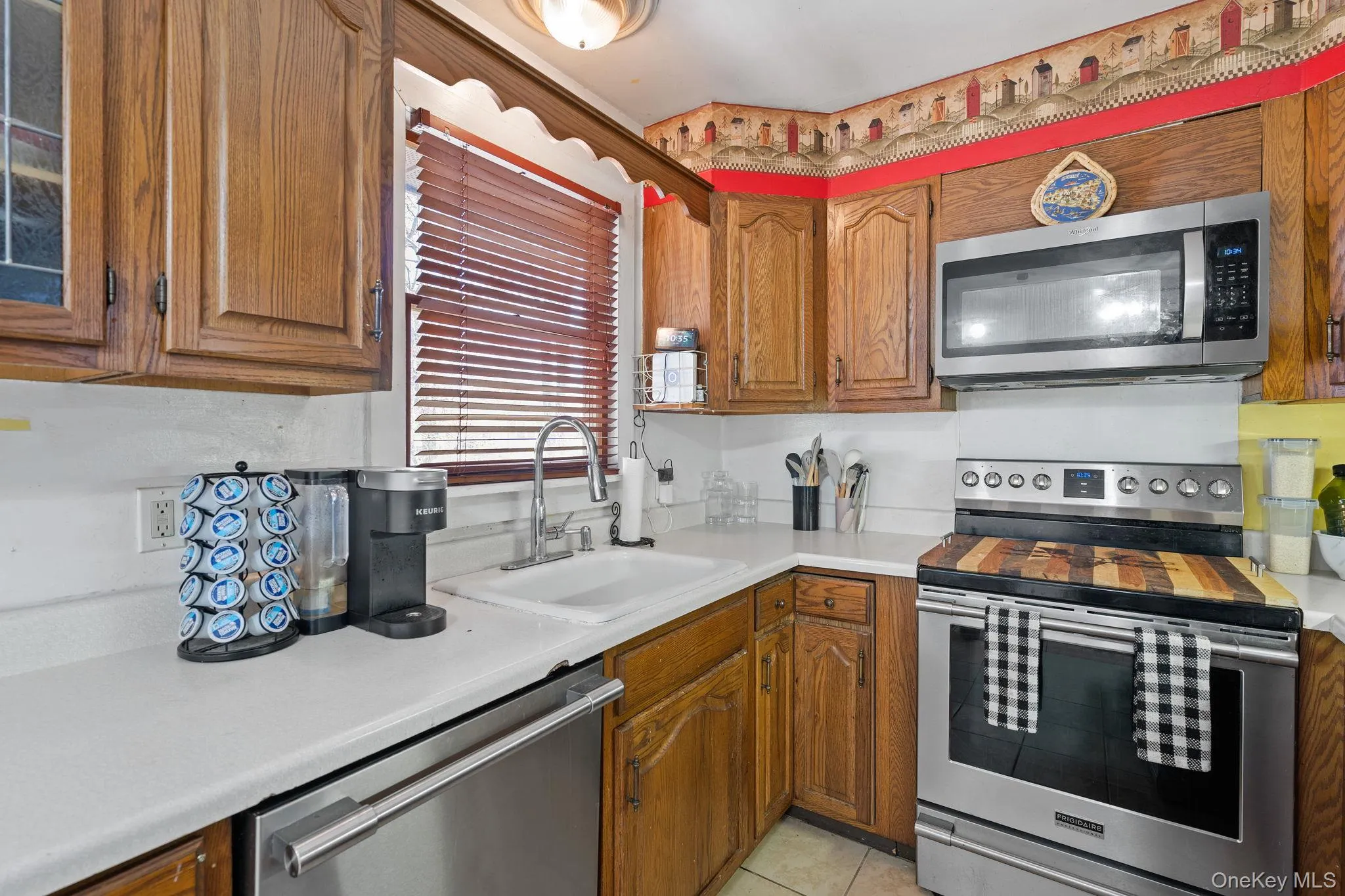 Kitchen featuring a sink, appliances with stainless steel finishes, and brown cabinetry Kitchen featuring a sink, appliances with stainless steel finishes, and brown cabinetry