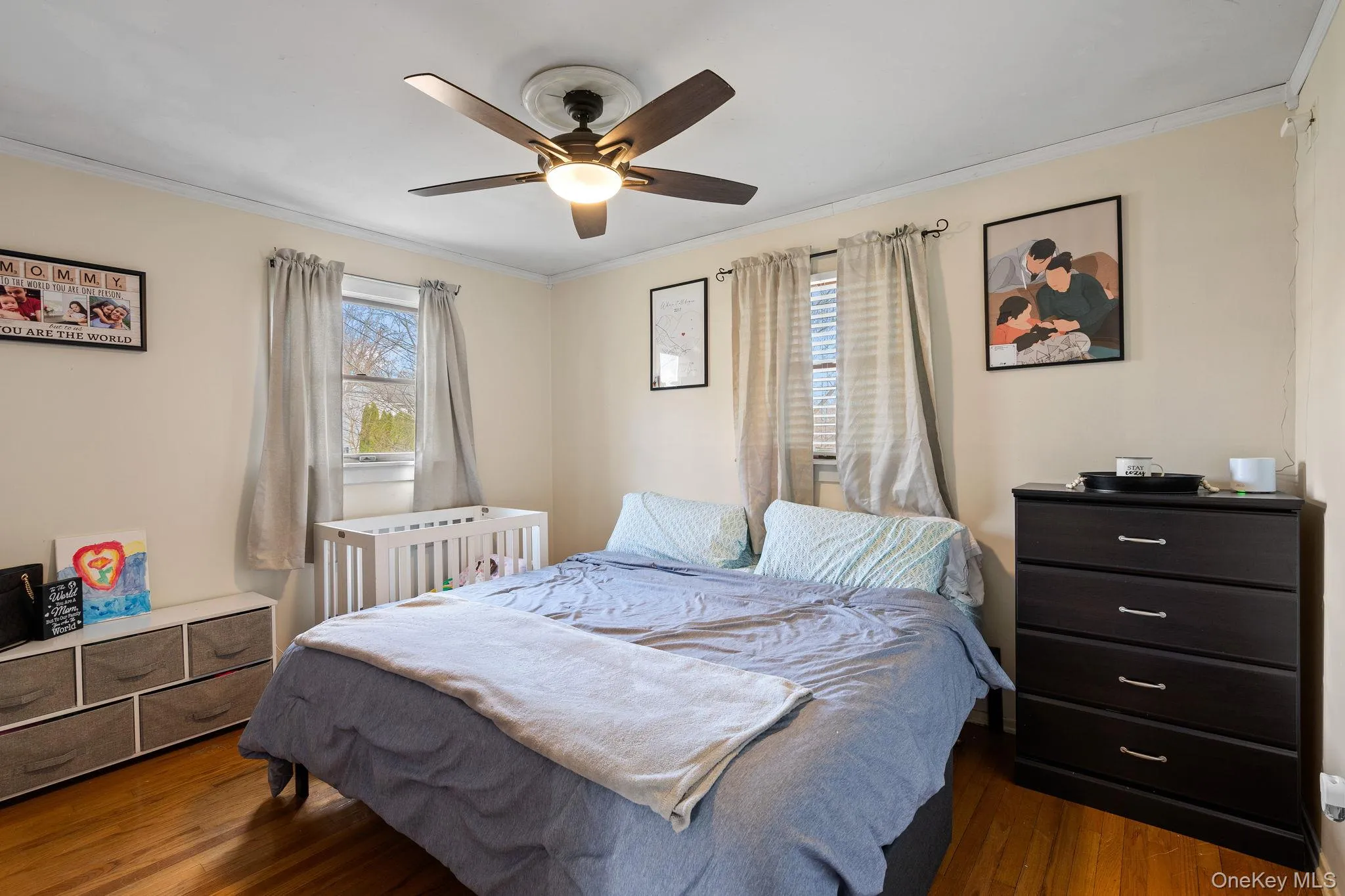 Bedroom featuring a ceiling fan, crown molding, and wood finished floors Bedroom featuring a ceiling fan, crown molding, and wood finished floors