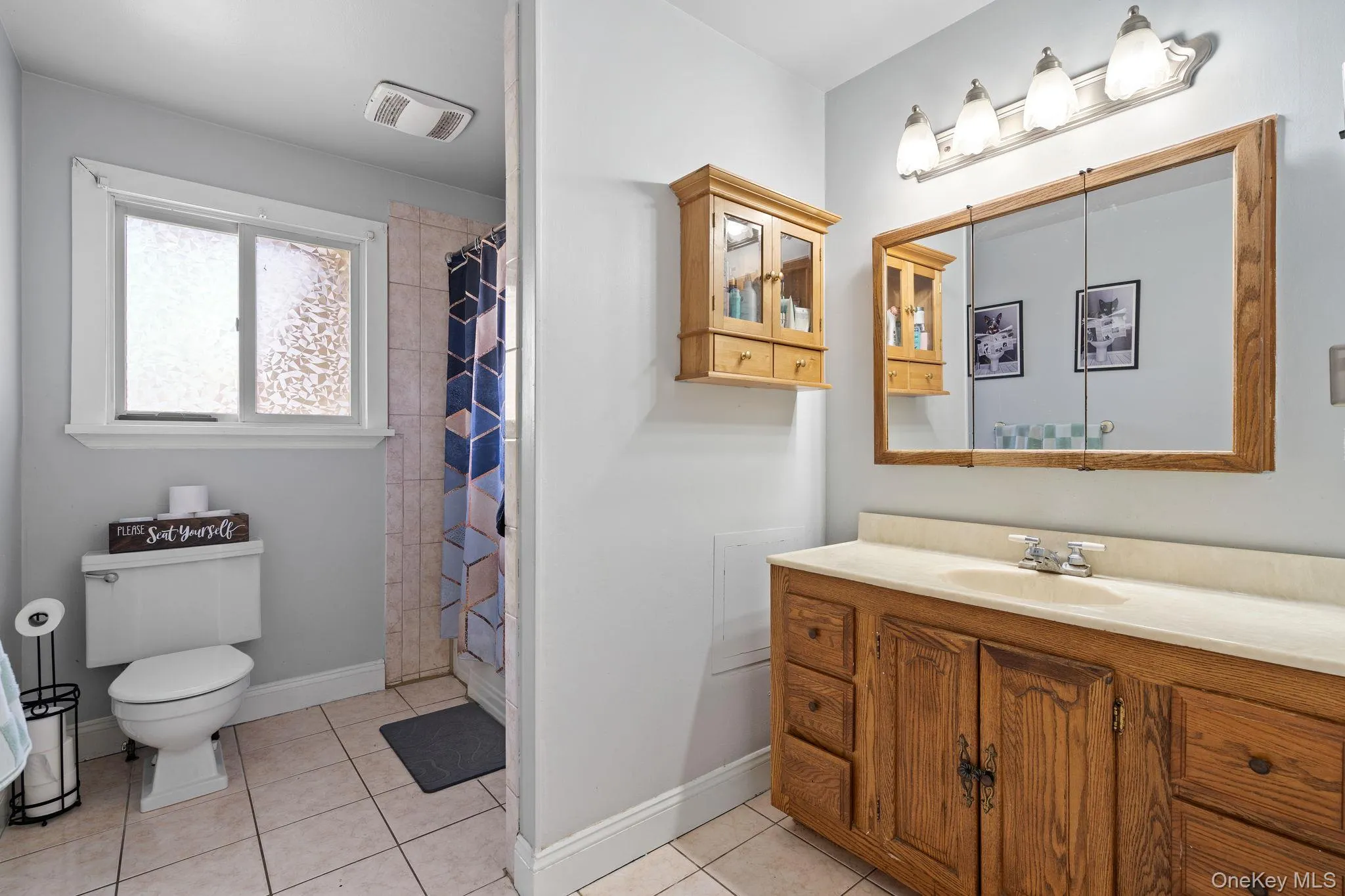Bathroom with visible vents, baseboards, toilet, vanity, and tile patterned flooring Bathroom with visible vents, baseboards, toilet, vanity, and tile patterned flooring