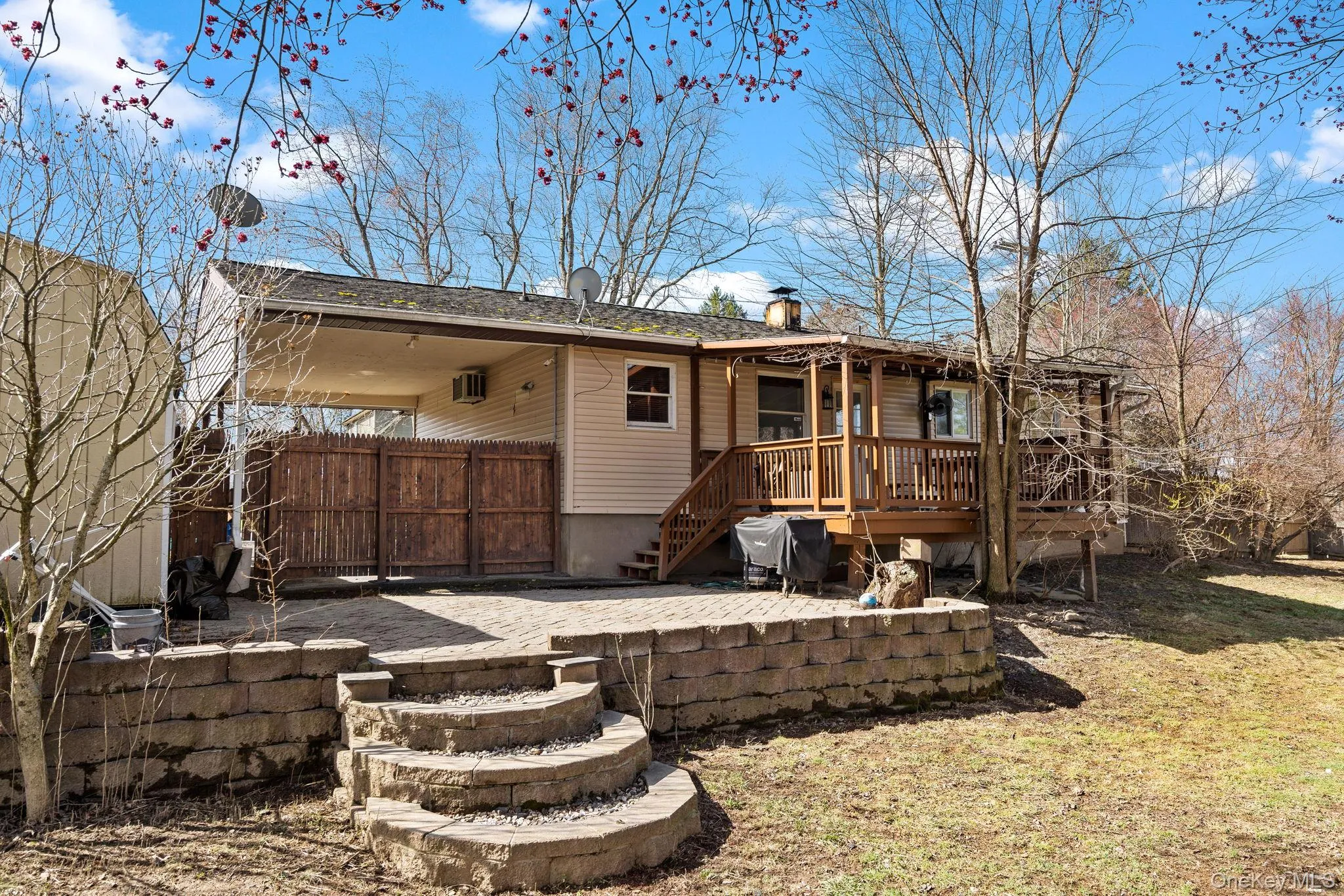Rear view of house featuring a patio, fence, and a wooden deck Rear view of house featuring a patio, fence, and a wooden deck