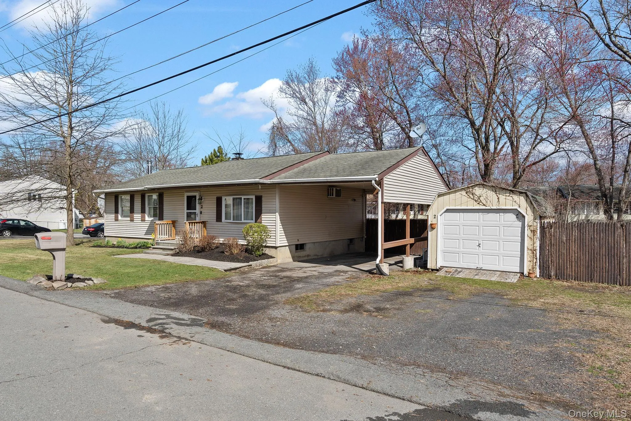 View of front of property featuring fence, an attached carport, driveway, a shingled roof, and an outdoor structure View of front of property featuring fence, an attached carport, driveway, a shingled roof, and an outdoor structure