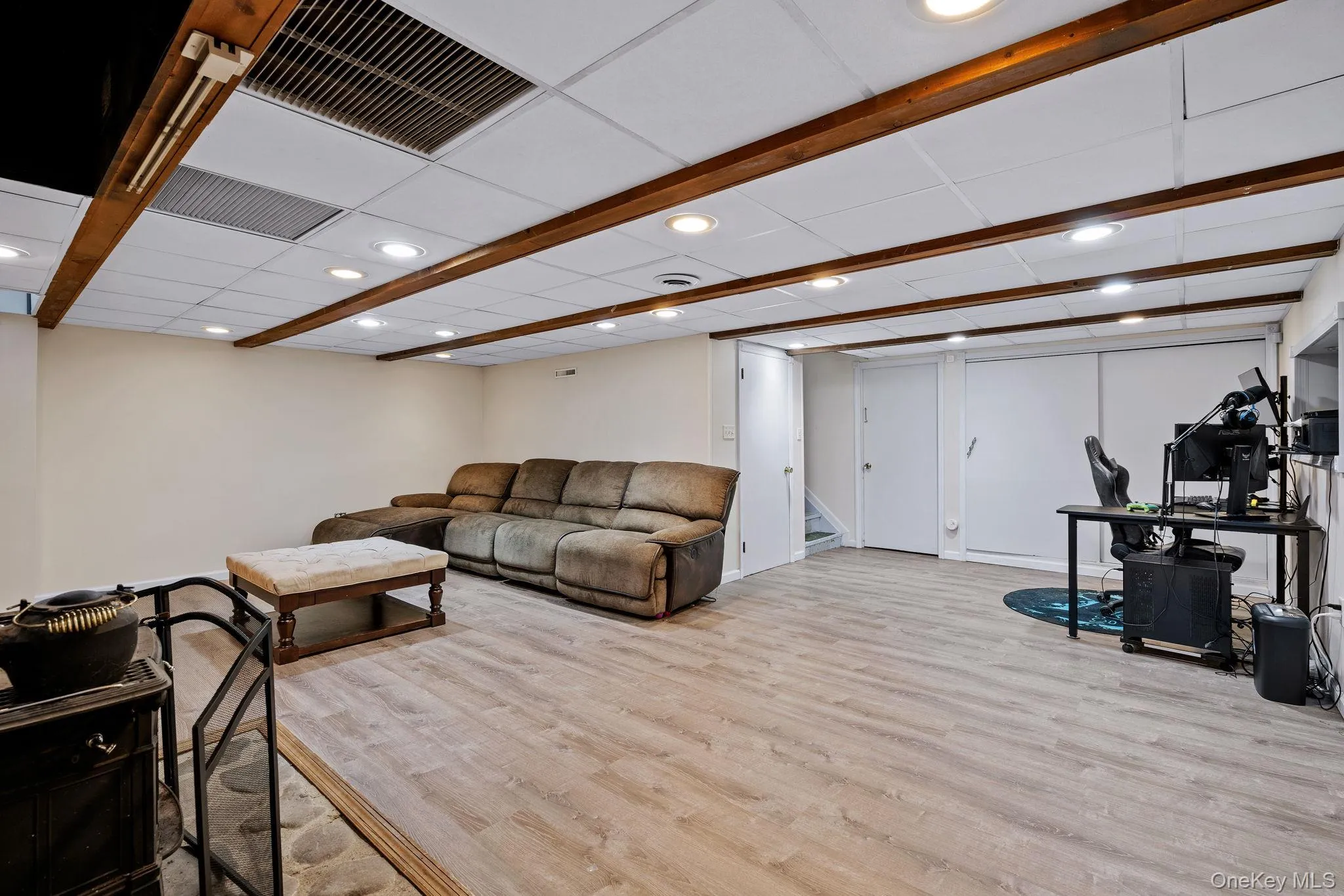 Living room with visible vents, a drop ceiling, stairway, and wood finished floors Living room with visible vents, a drop ceiling, stairway, and wood finished floors
