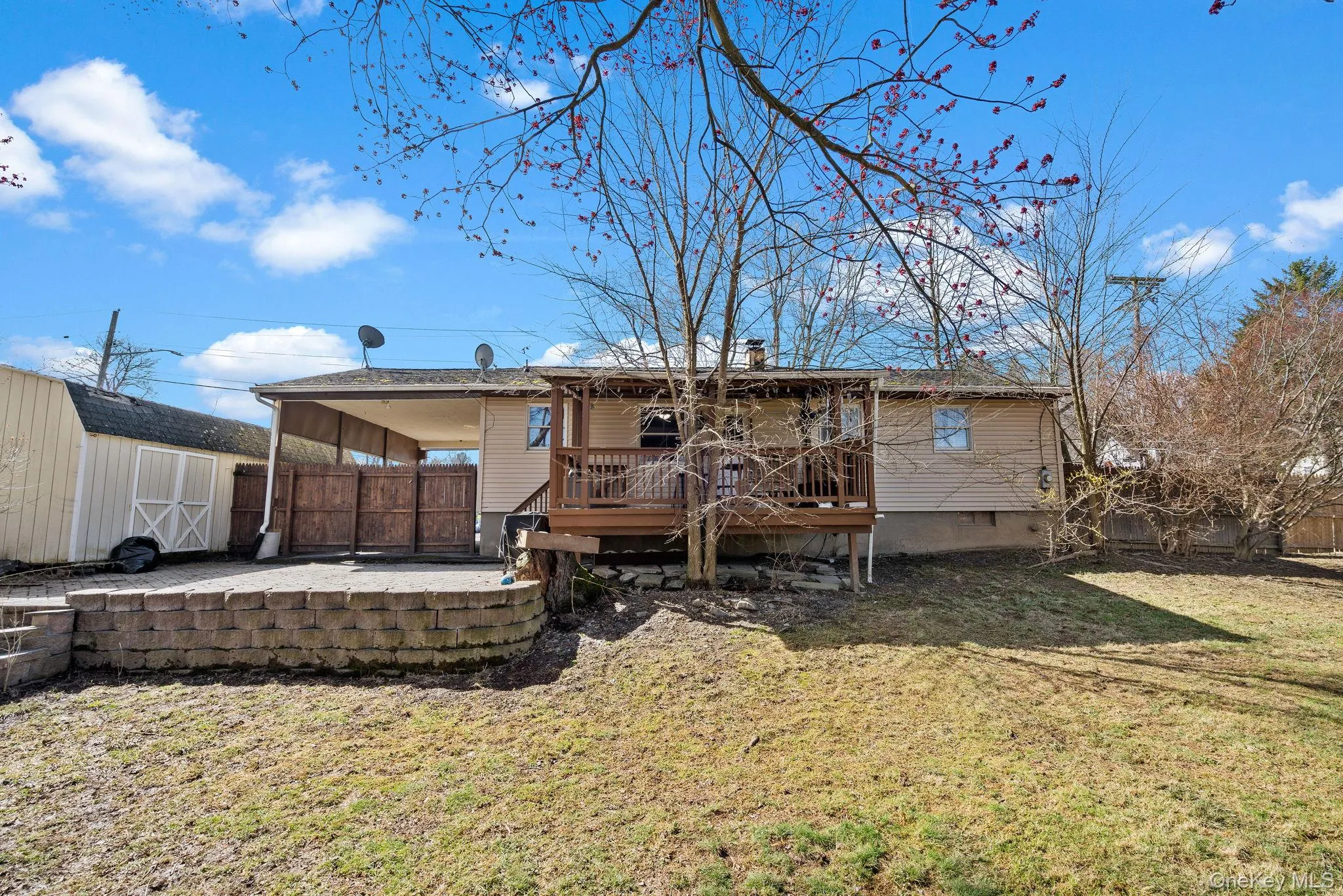 Back of house with a shed, a wooden deck, fence, an outdoor structure, and a yard Back of house with a shed, a wooden deck, fence, an outdoor structure, and a yard