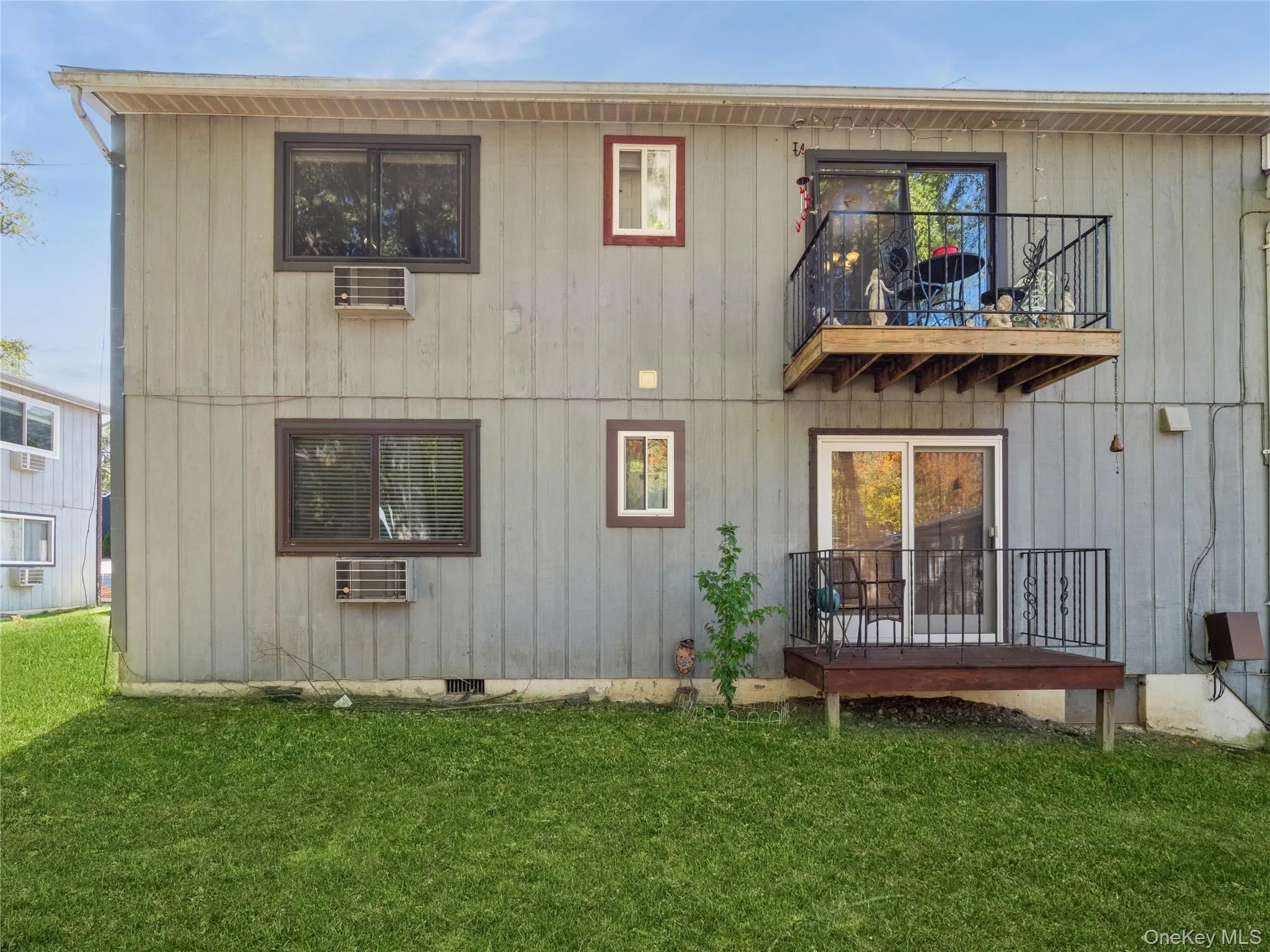 Rear view of property with a balcony and a lawn Rear view of property with a balcony and a lawn