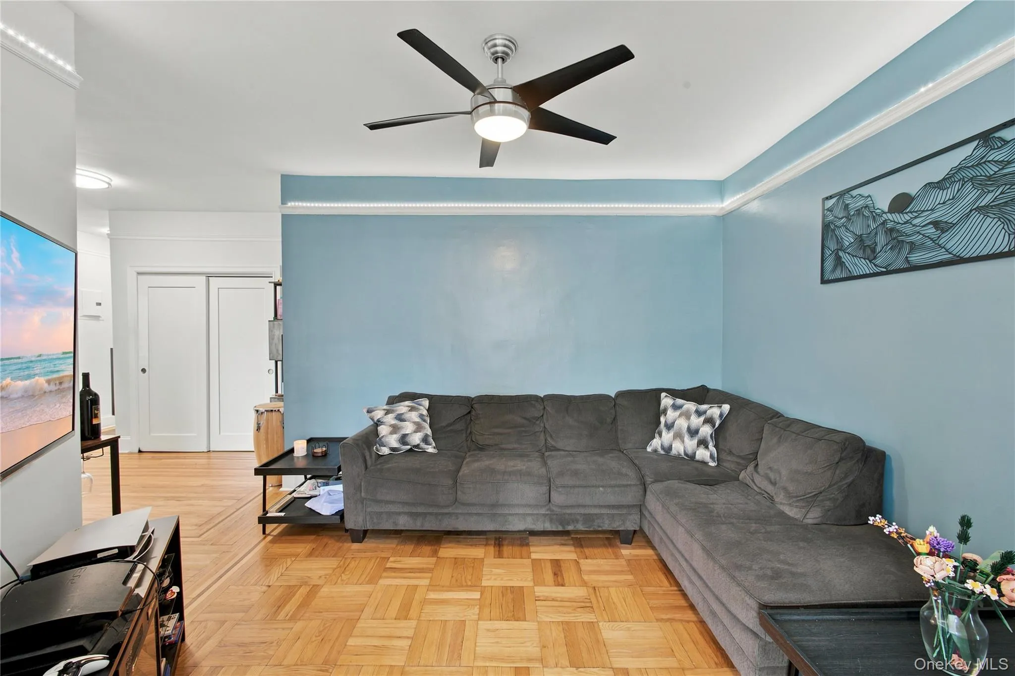 Living area featuring parquet wood flooring and light blue walls Living area featuring parquet wood flooring and light blue walls