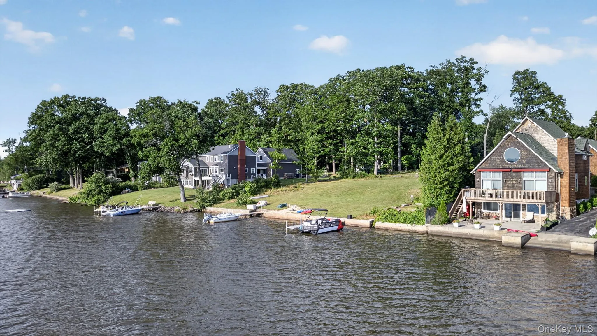 Waterfront property featuring extensive shoreline access, a private boat dock, a multi-level deck, and a circular window accent Waterfront property featuring extensive shoreline access, a private boat dock, a multi-level deck, and a circular window accent