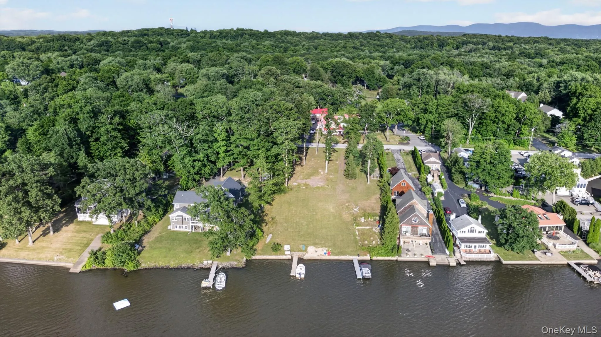 Waterfront property featuring a private dock, expansive green space, and mature trees Waterfront property featuring a private dock, expansive green space, and mature trees