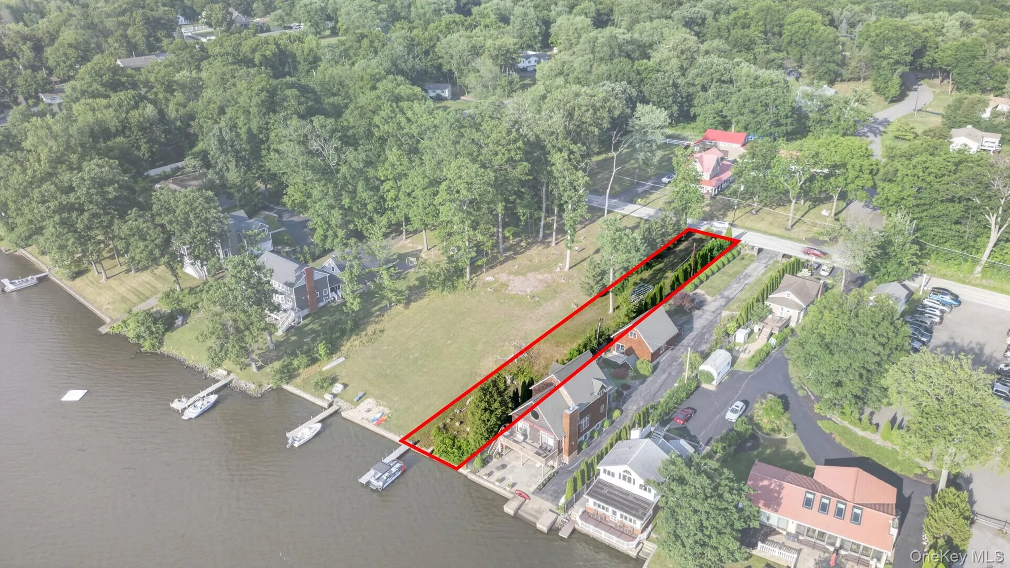 Waterfront parcel featuring a defined red boundary and mature trees Waterfront parcel featuring a defined red boundary and mature trees
