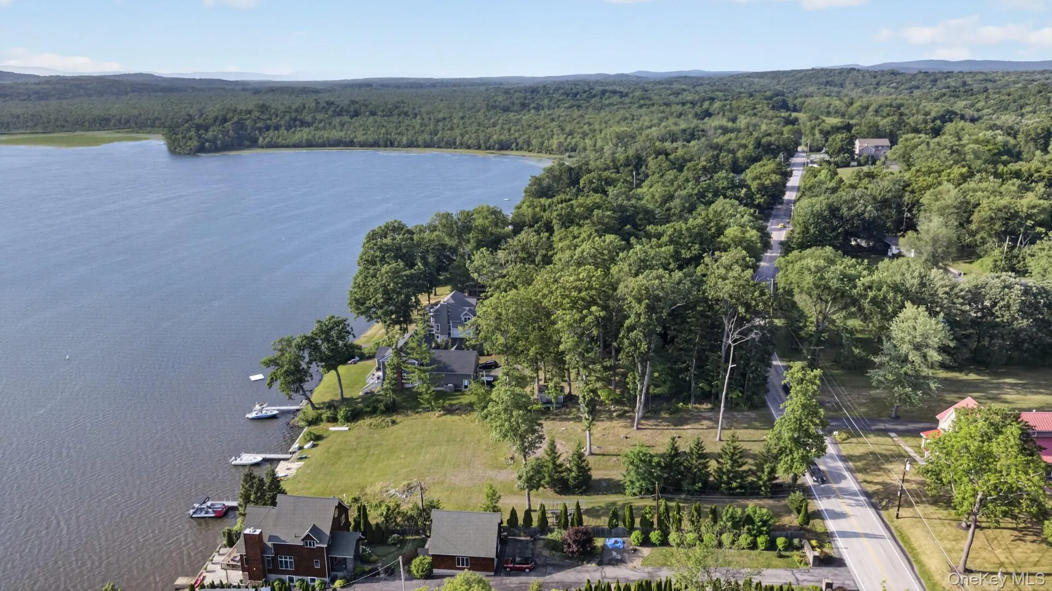 Expansive waterfront property featuring a substantial lakefront, private docks, and lush green lawns Expansive waterfront property featuring a substantial lakefront, private docks, and lush green lawns