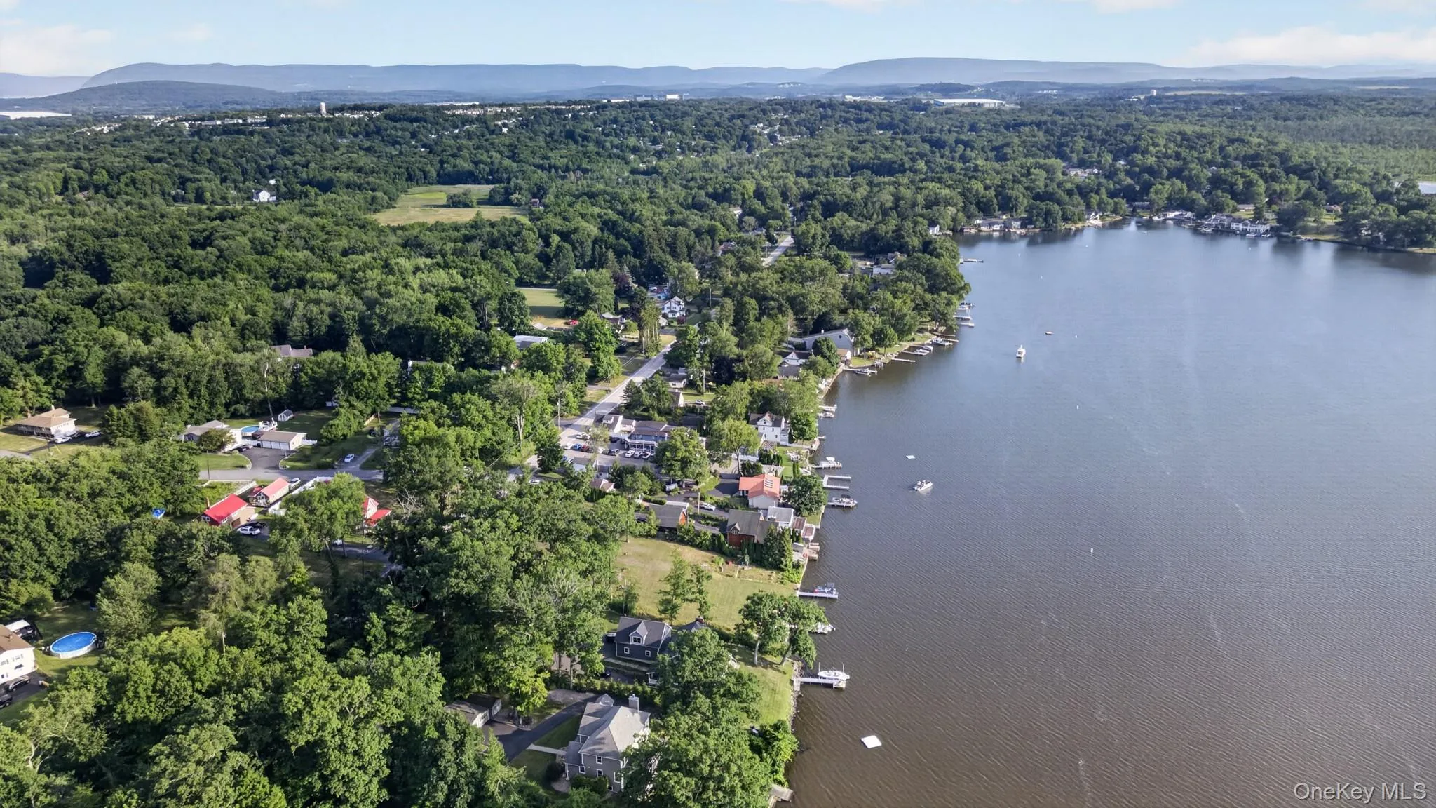 Aerial perspective showcasing a waterfront community with extensive tree cover Aerial perspective showcasing a waterfront community with extensive tree cover