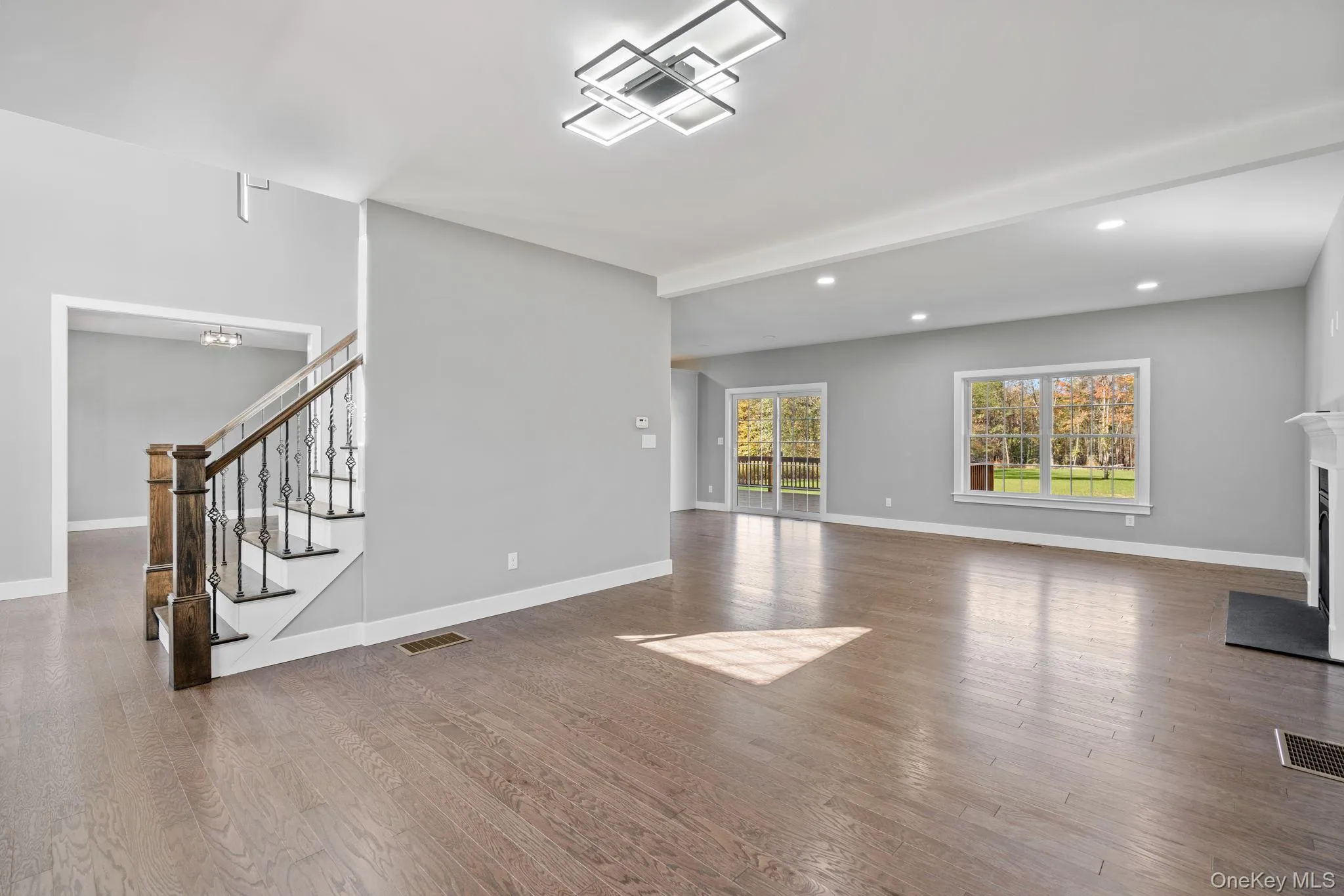 Unfurnished living room with recessed lighting, visible vents, baseboards, and wood finished floors Unfurnished living room with recessed lighting, visible vents, baseboards, and wood finished floors