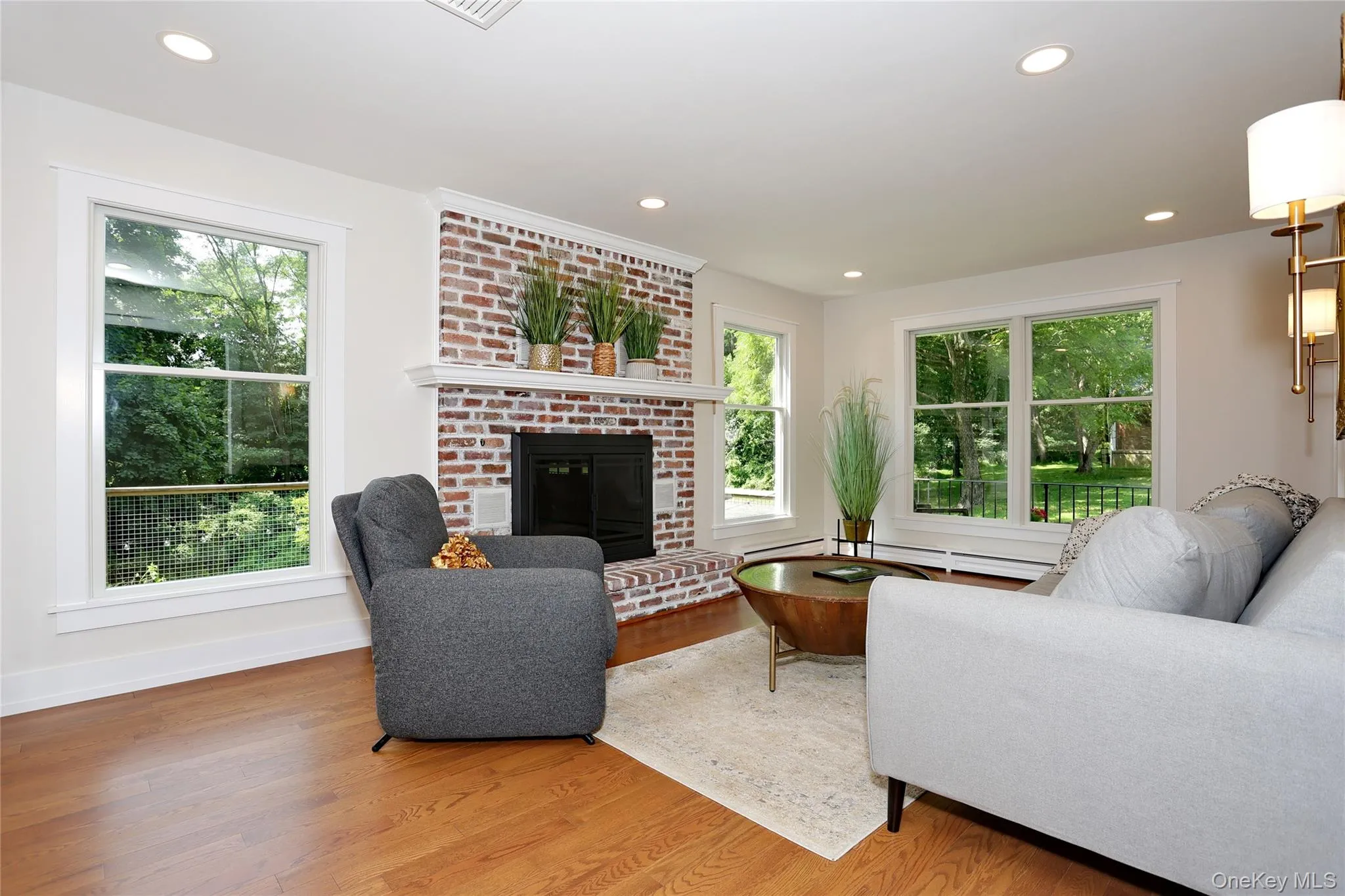 Welcoming living room with wood-burning fireplace and views of landscape. Welcoming living room with wood-burning fireplace and views of landscape.