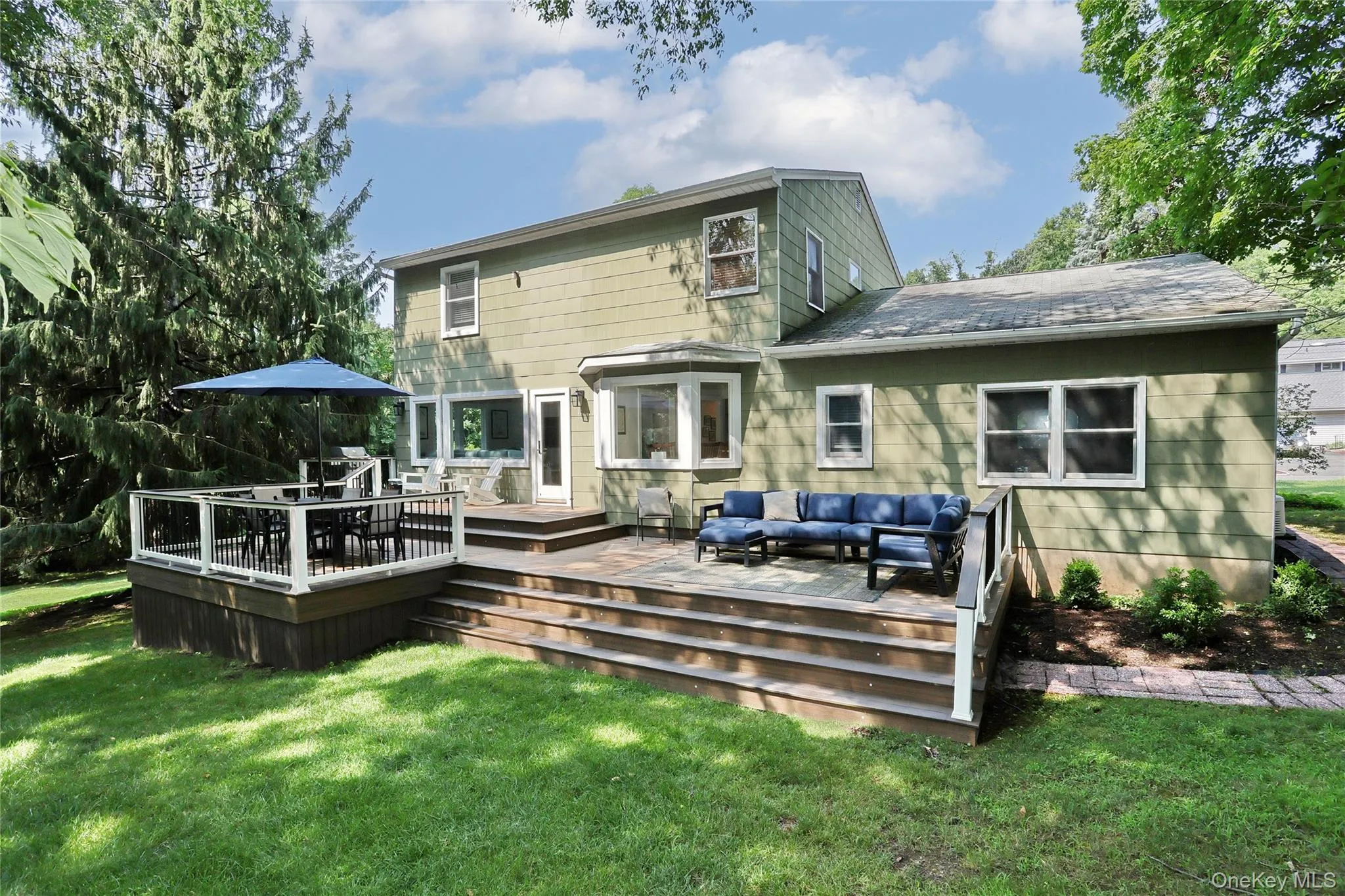 Back of the house with tiered trex deck for dining and lounging. Back of the house with tiered trex deck for dining and lounging.