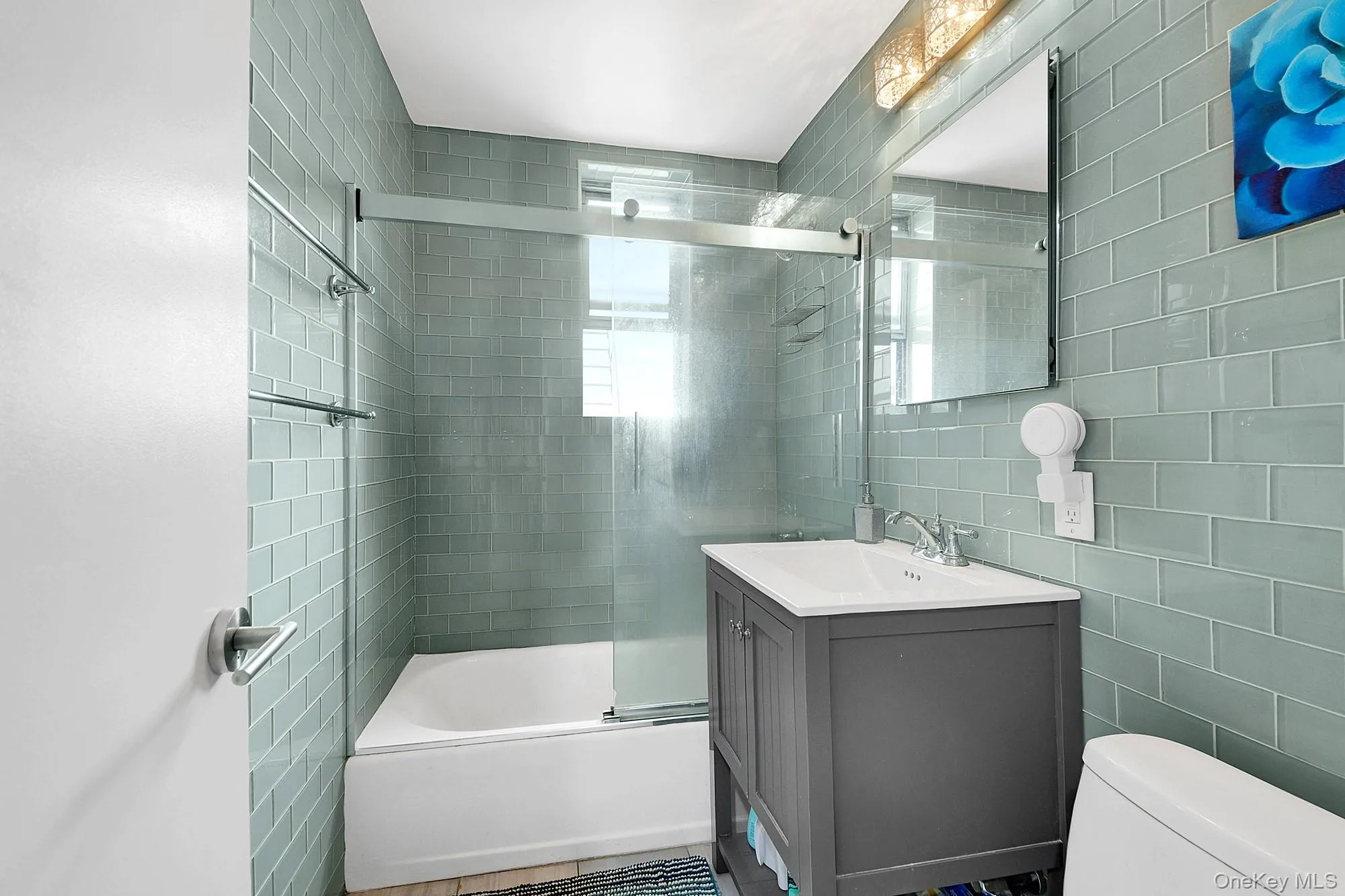 Updated windowed bathroom with glass subway tiles, soaking tub and updated fixtures. Updated windowed bathroom with glass subway tiles, soaking tub and updated fixtures.
