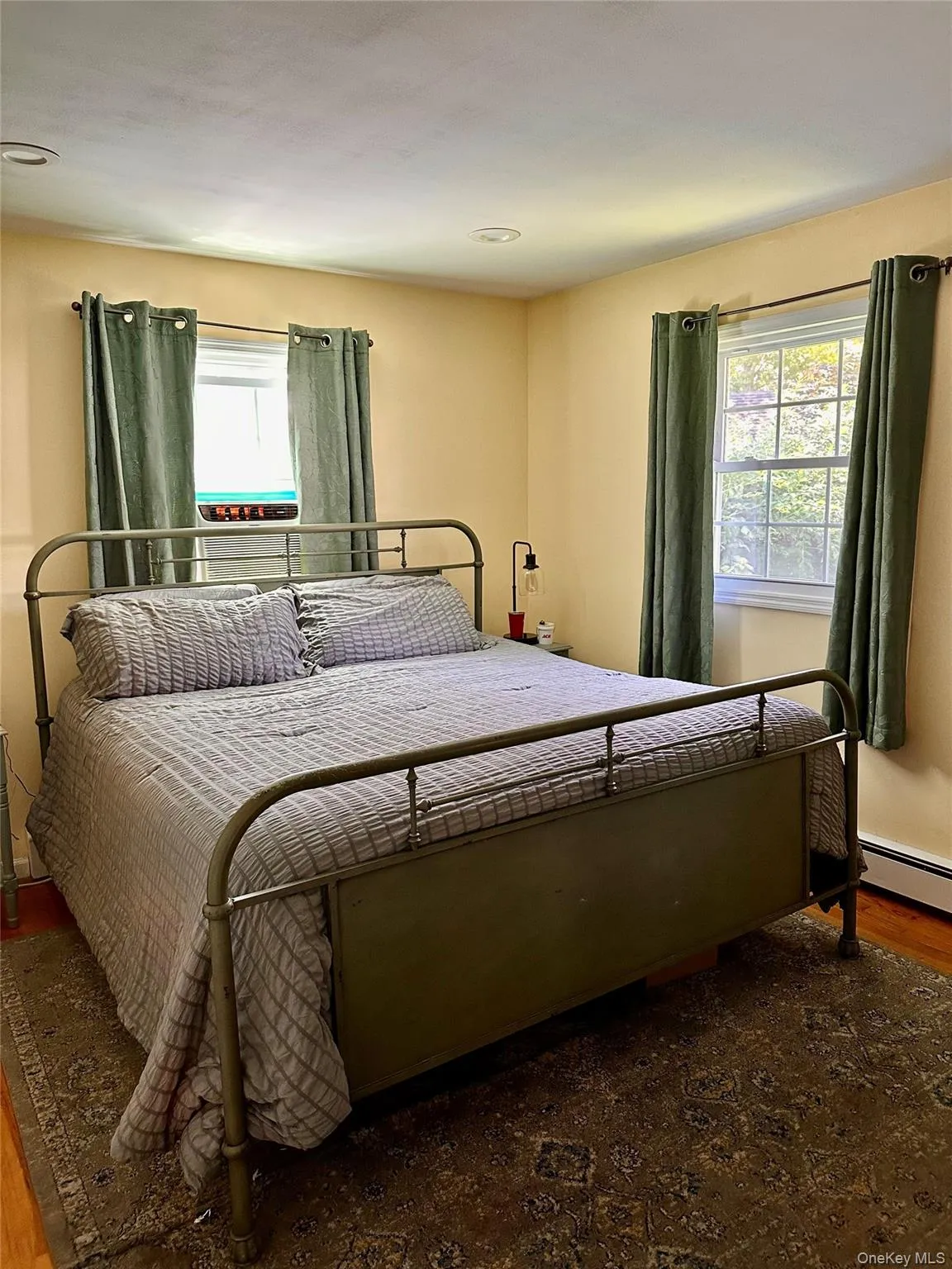 Bedroom featuring two windows, recessed lighting, and wood-finish flooring Bedroom featuring two windows, recessed lighting, and wood-finish flooring