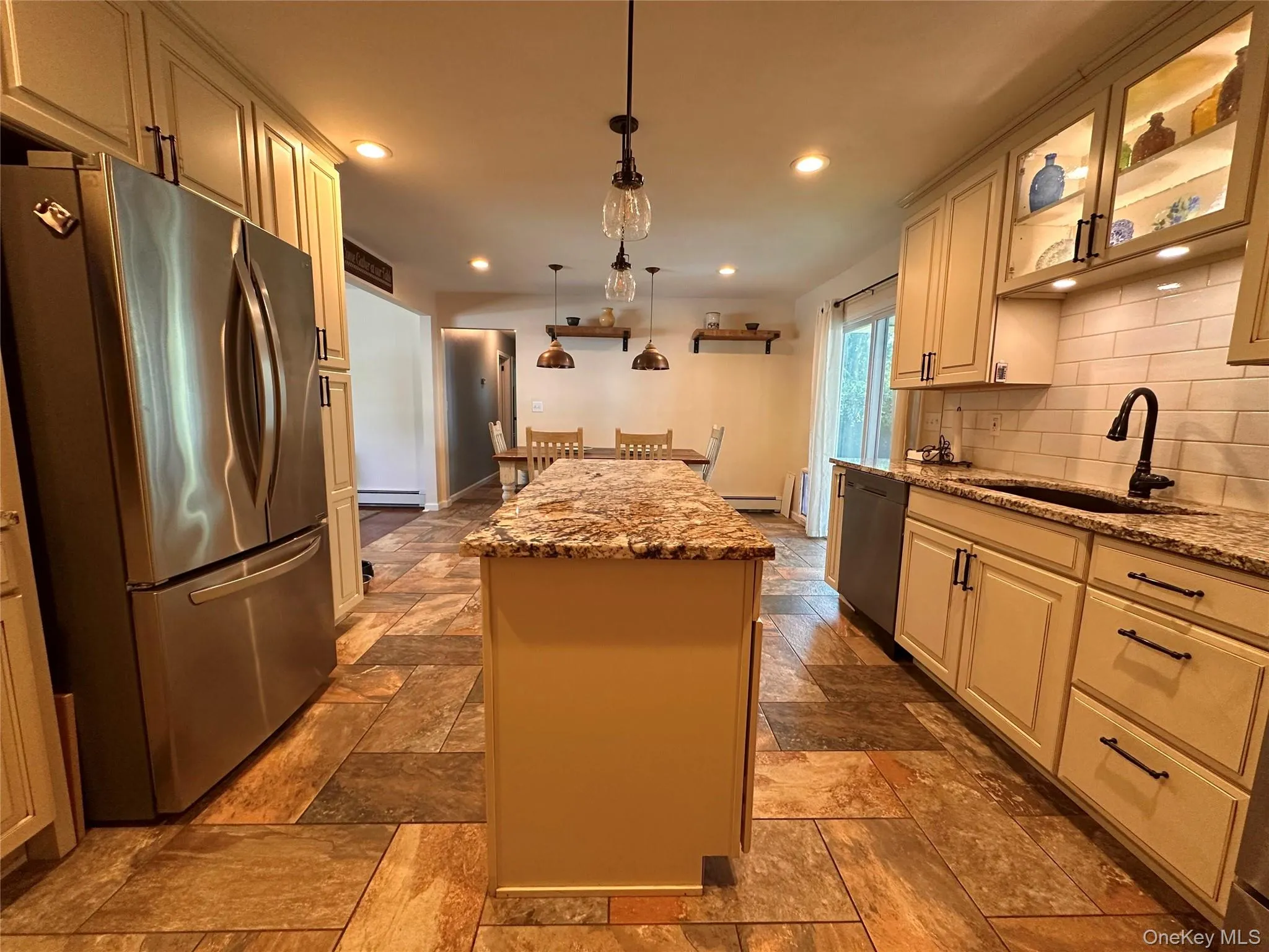 Kitchen featuring a central island with a stone-finish countertop, stainless steel appliances, white subway tile backsplash, and recessed lighting Kitchen featuring a central island with a stone-finish countertop, stainless steel appliances, white subway tile backsplash, and recessed lighting