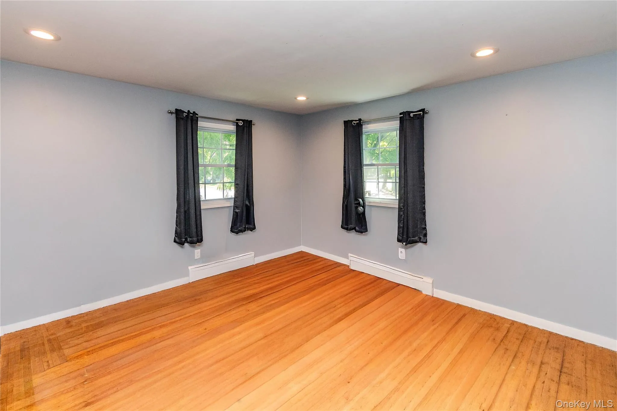 Bedroom 3 Hardwood flooring, recessed lighting, and two windows with trim Bedroom 3 Hardwood flooring, recessed lighting, and two windows with trim