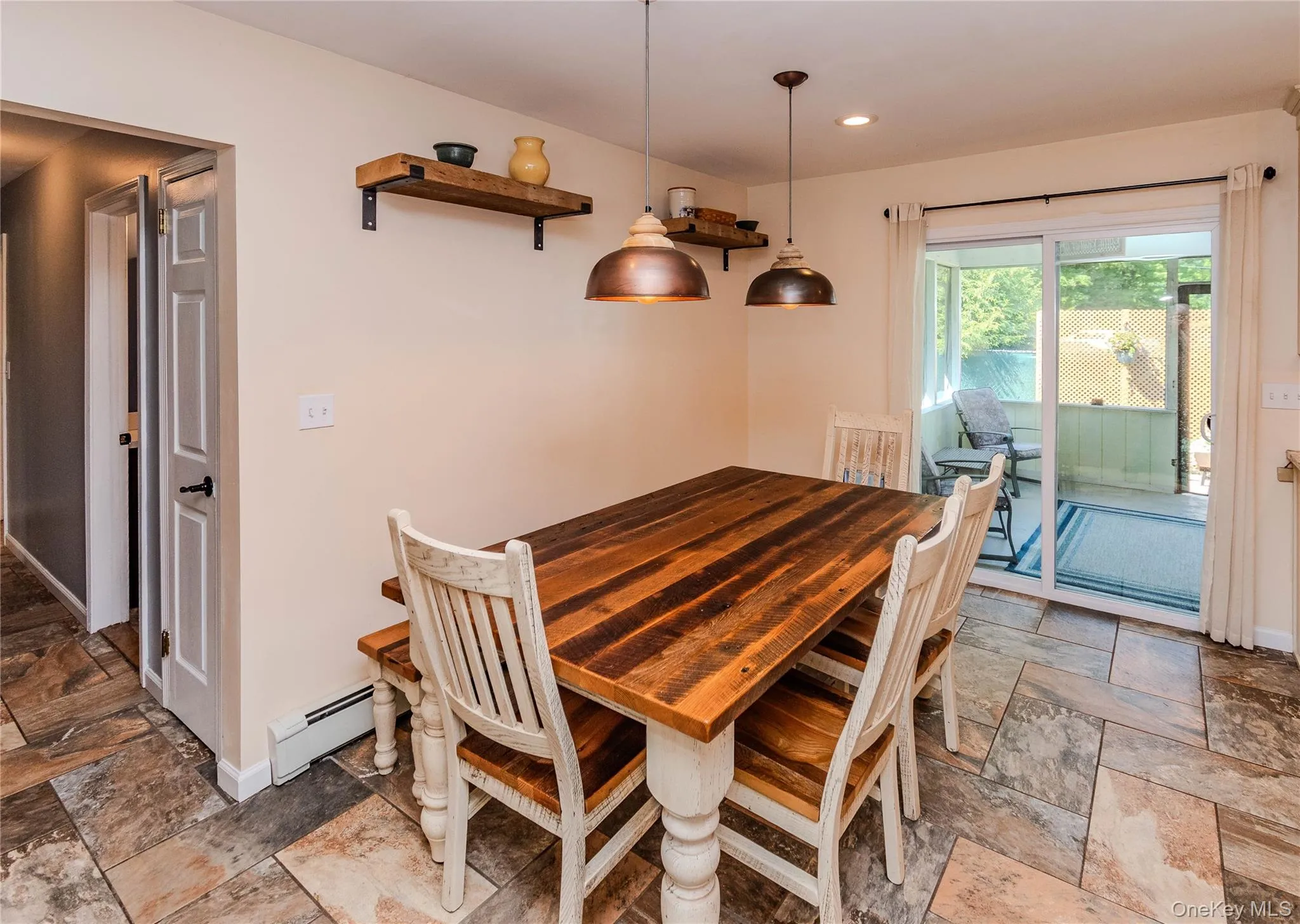 Tiled flooring throughout, featuring a dining area with two pendant lights and open shelving Tiled flooring throughout, featuring a dining area with two pendant lights and open shelving
