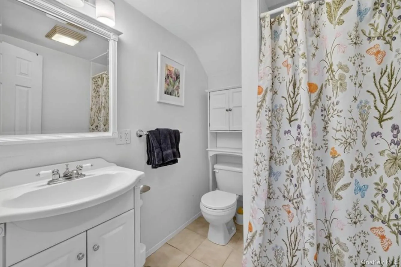 Bathroom featuring walk in shower, vanity, and light tile patterned flooring Bathroom featuring walk in shower, vanity, and light tile patterned flooring