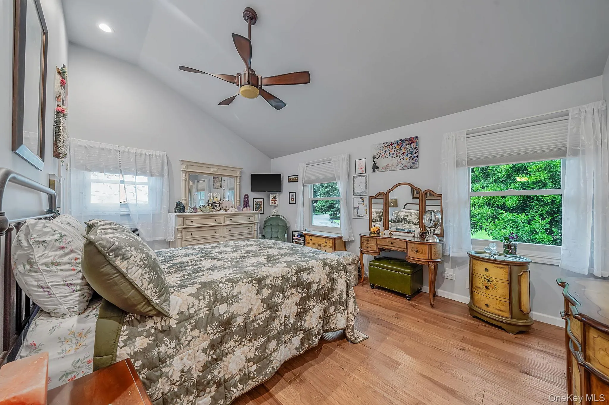 Vaulted ceiling with recessed lighting and a ceiling fan, wood look tile, multiple windows with blinds, and white painted walls Vaulted ceiling with recessed lighting and a ceiling fan, wood look tile, multiple windows with blinds, and white painted walls