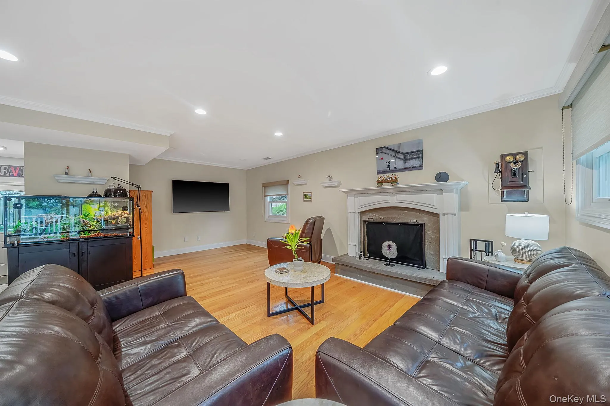 Bright family room featuring hardwood flooring, recessed lighting, and crown molding Bright family room featuring hardwood flooring, recessed lighting, and crown molding