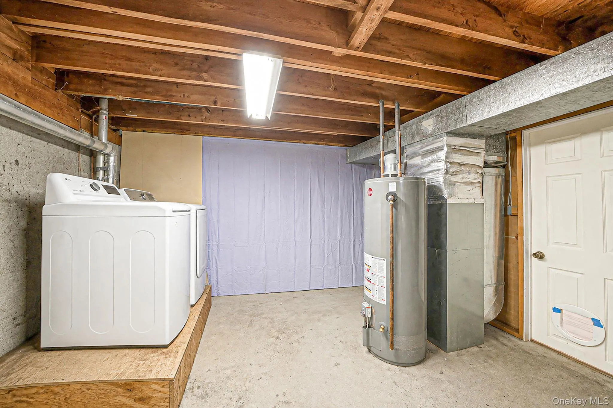Unfinished section of basement with washer/dryer area and HVAC equipment Unfinished section of basement with washer/dryer area and HVAC equipment