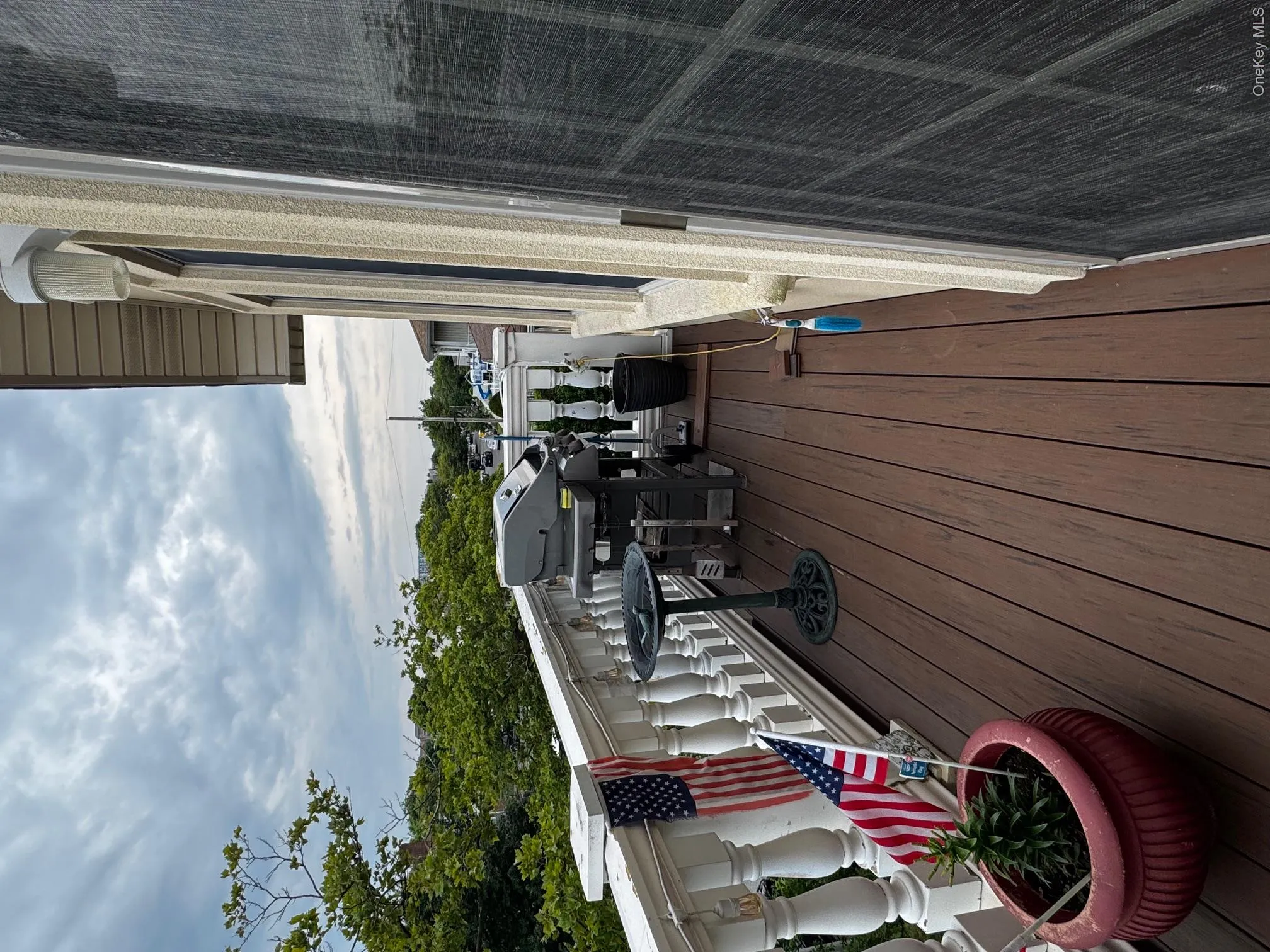 Wooden terrace featuring a grill Wooden terrace featuring a grill