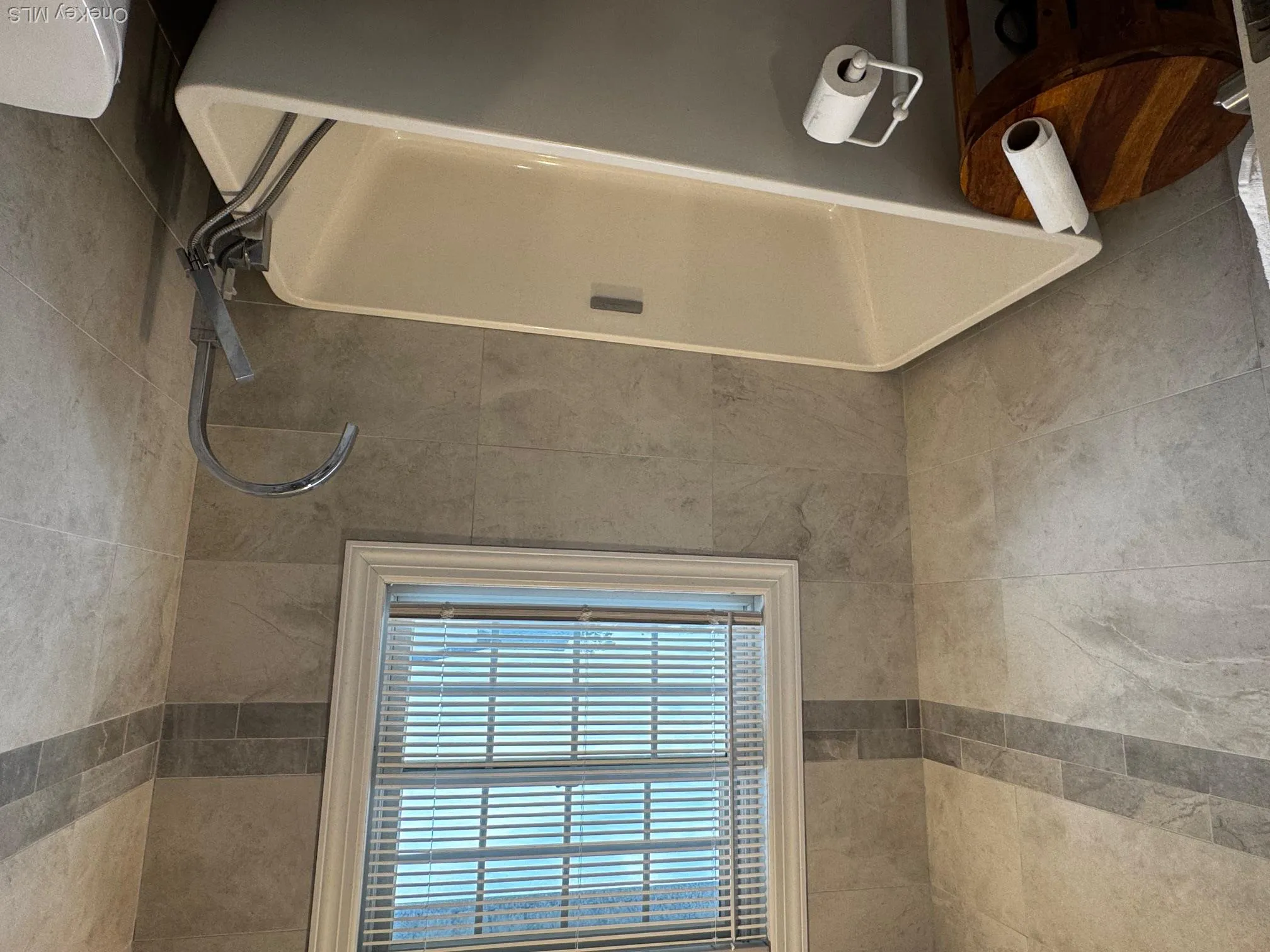 Full bath featuring tile walls and a freestanding tub Full bath featuring tile walls and a freestanding tub