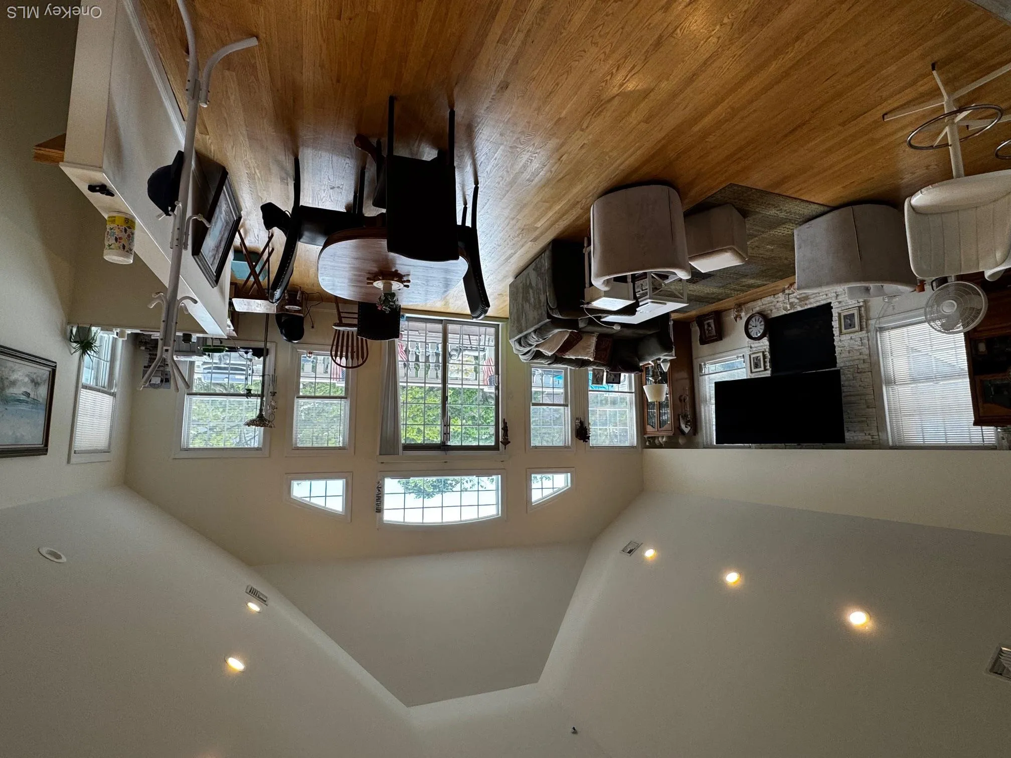 Dining space featuring wood finished floors, recessed lighting, a fireplace, and high vaulted ceiling Dining space featuring wood finished floors, recessed lighting, a fireplace, and high vaulted ceiling