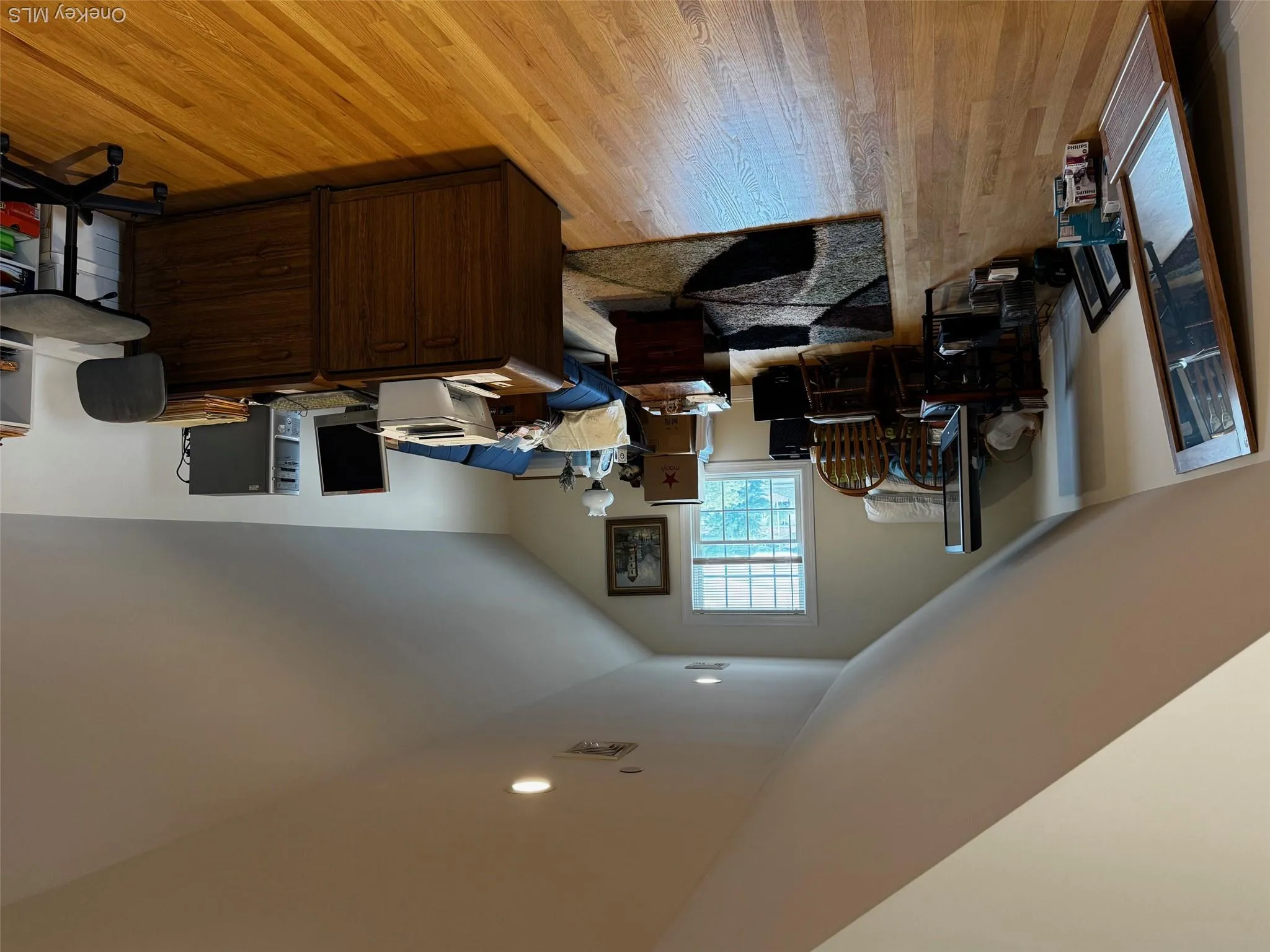 Office area with light wood-style flooring and lofted ceiling Office area with light wood-style flooring and lofted ceiling