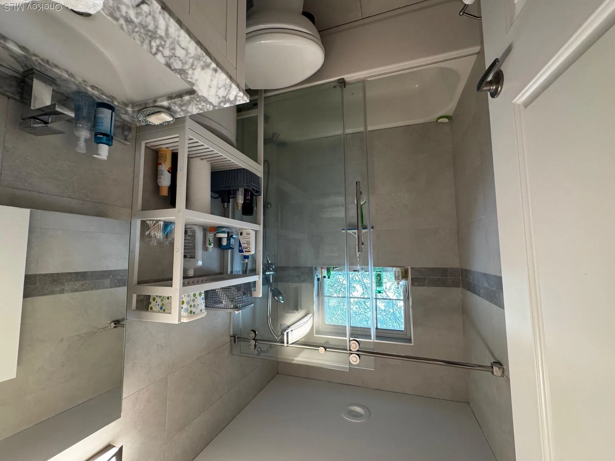 Full bath with vanity, tile walls, and bath / shower combo with glass door Full bath with vanity, tile walls, and bath / shower combo with glass door